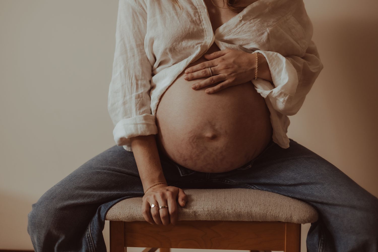 A series of maternity photos showing a pregnant belly in various intimate poses against a warm neutral background.