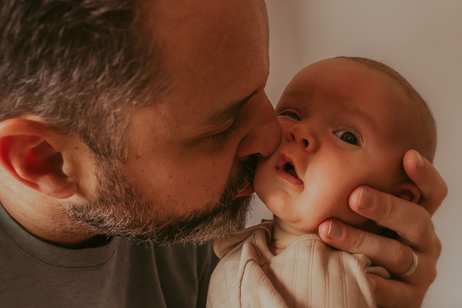 A tender moment between a parent and baby shown in a series of close-up photos.