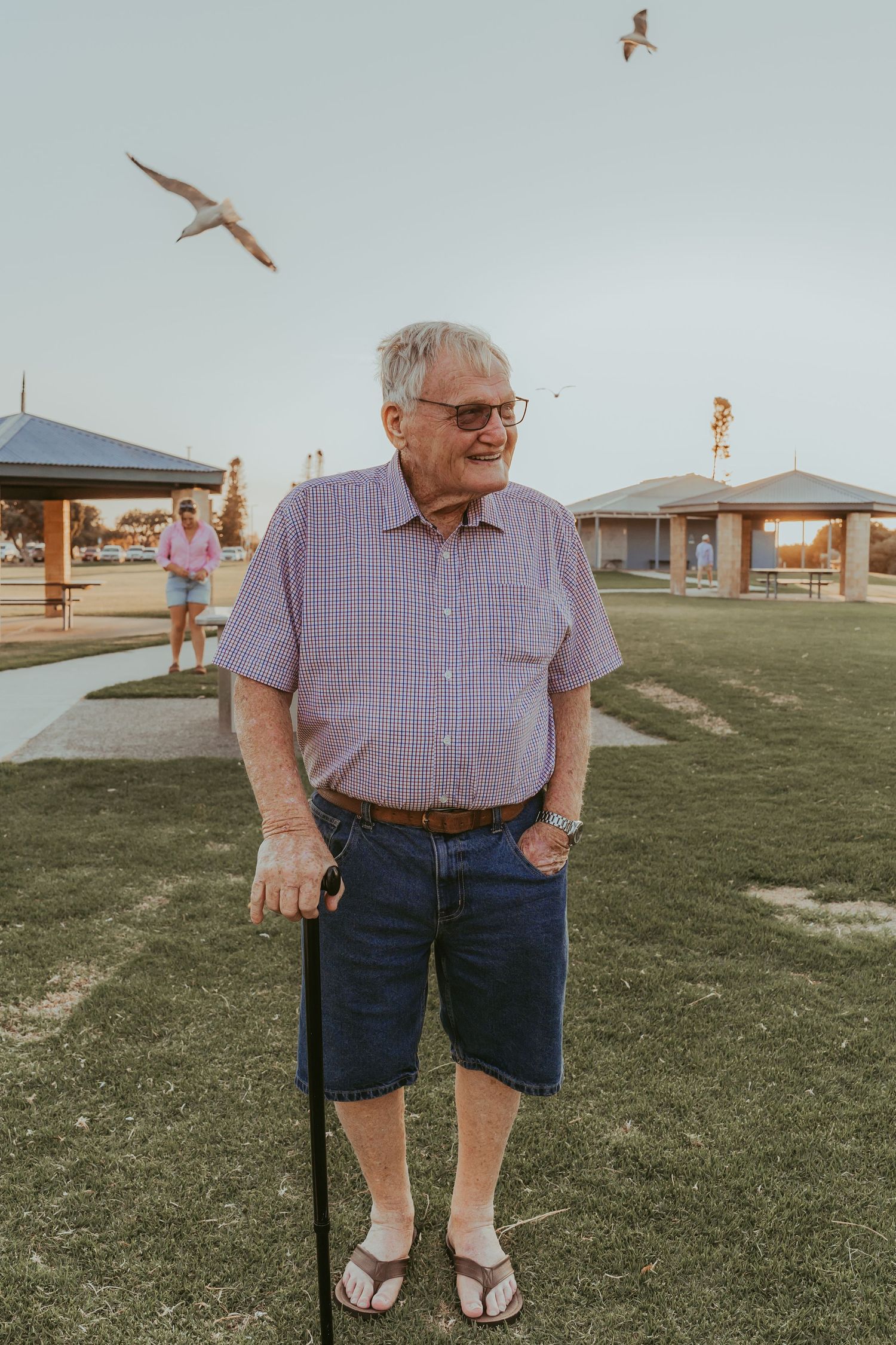 A series of five photos showing someone wearing a purple checkered shirt and blue shorts standing in a grassy field.