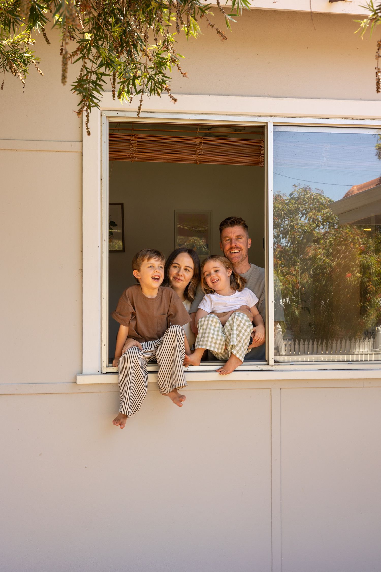 A family looks out through a window together in a series of connected photos showing different poses and expressions.