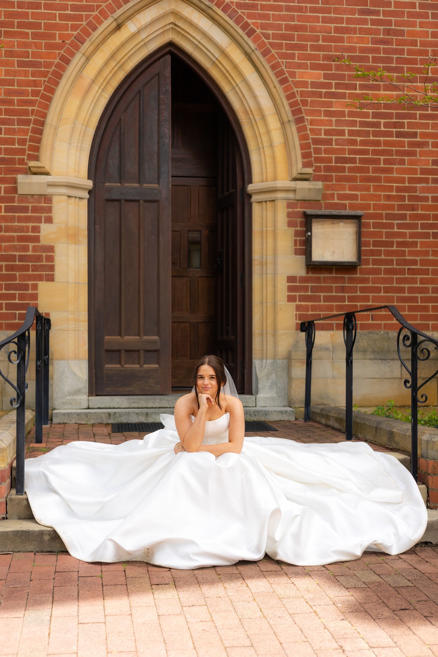 A creative wedding photo collage showing people lying on brick pavement in white dresses in front of a church entrance.