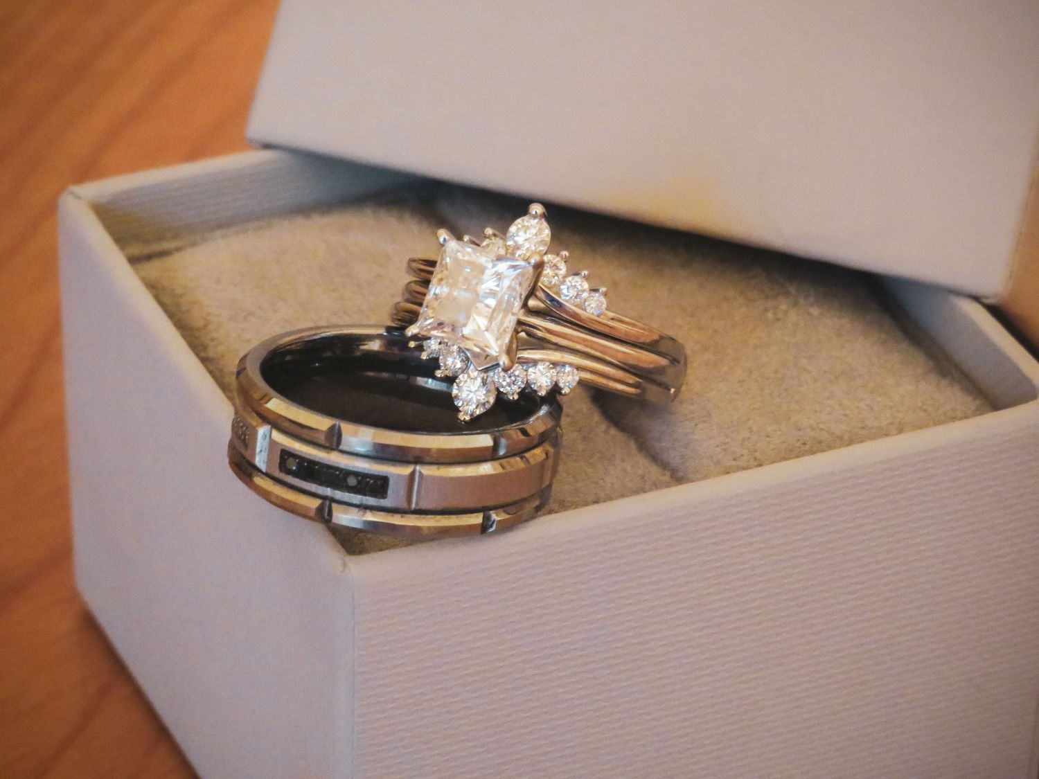 Wedding rings and jewelry displayed in elegant white gift boxes.