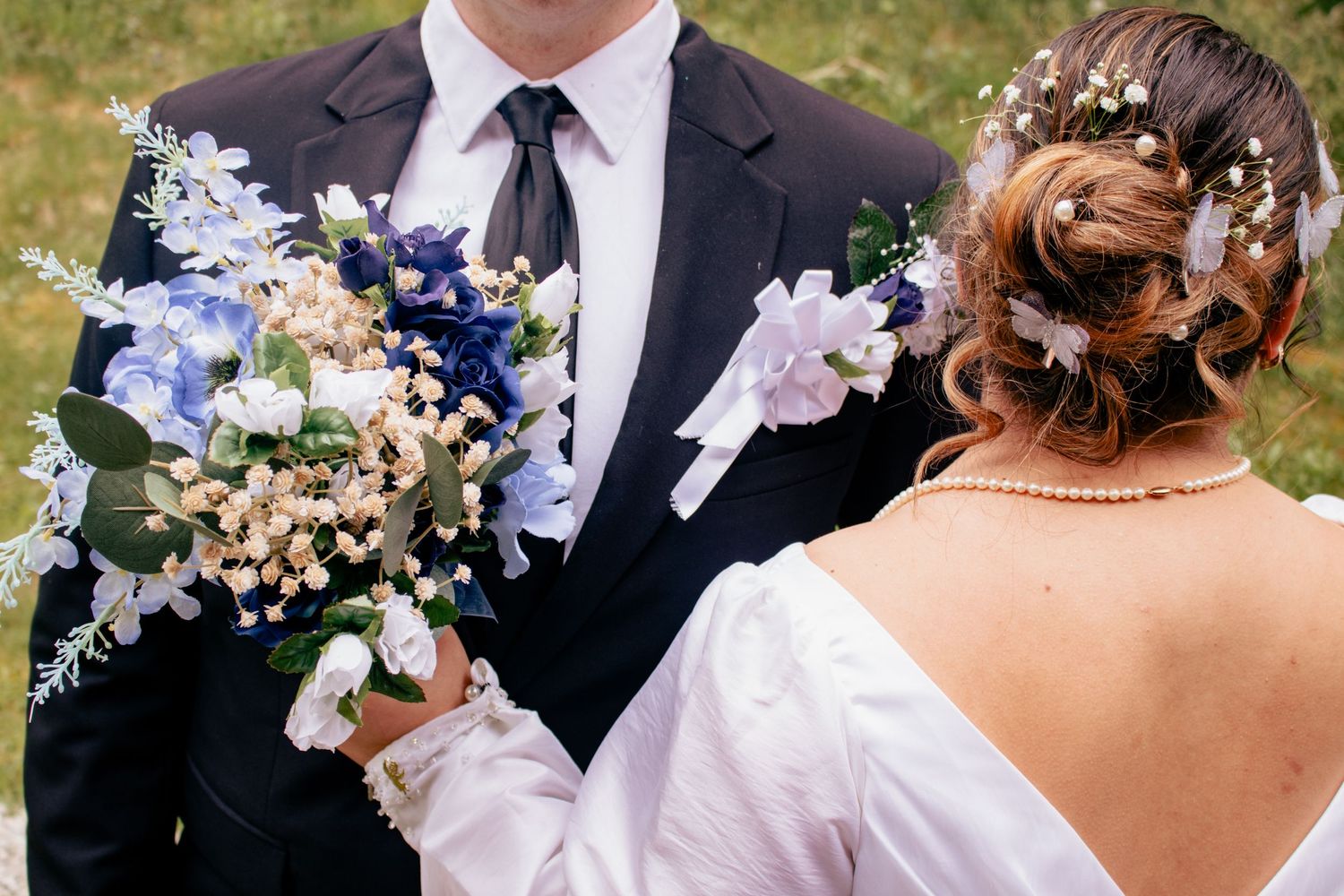 Close-up of wedding couple with beautiful purple and white floral bouquet.