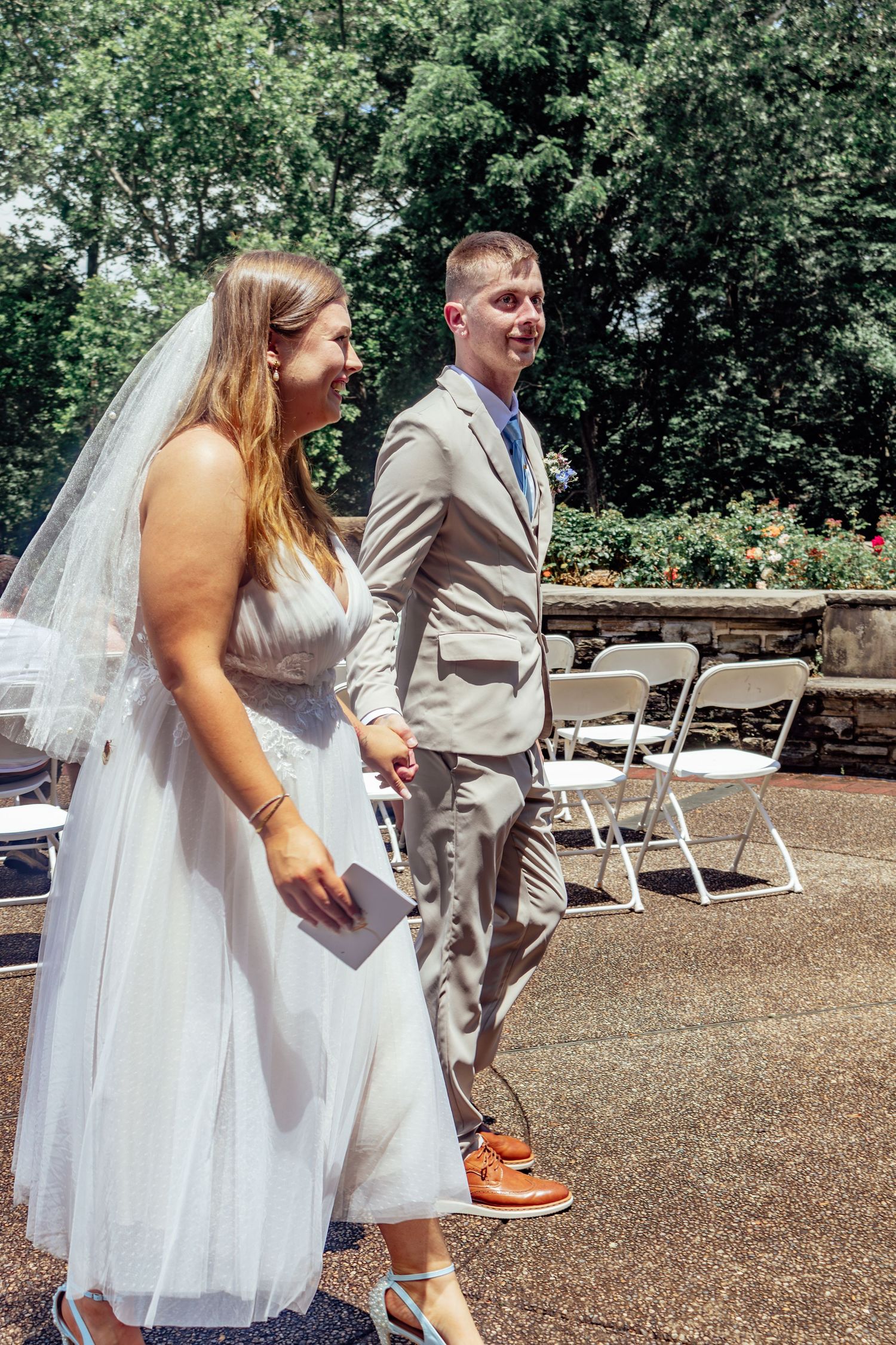A candid wedding photo showing a joyful moment outdoors with casual footwear.