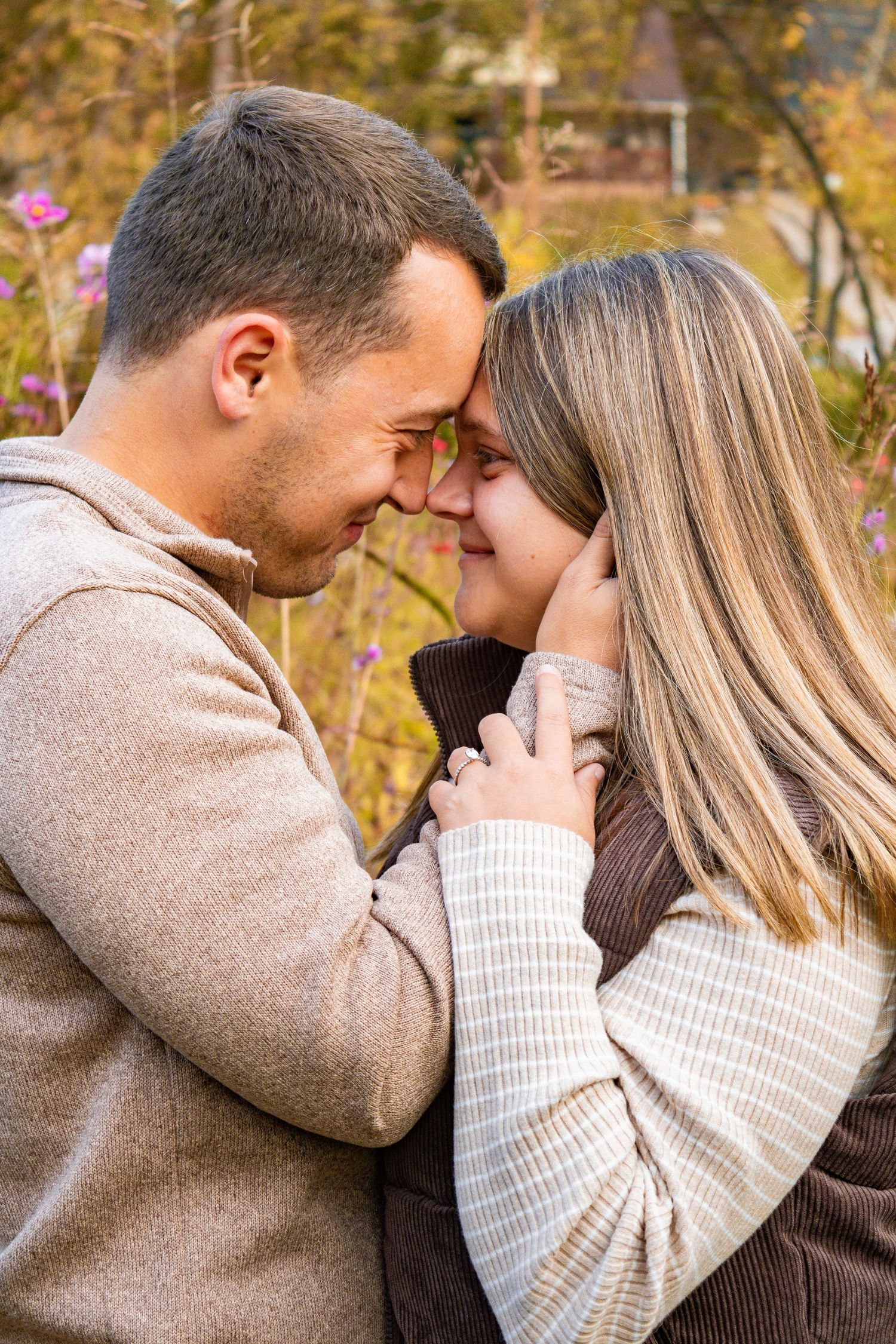 Tender moment between couple during autumn engagement session.