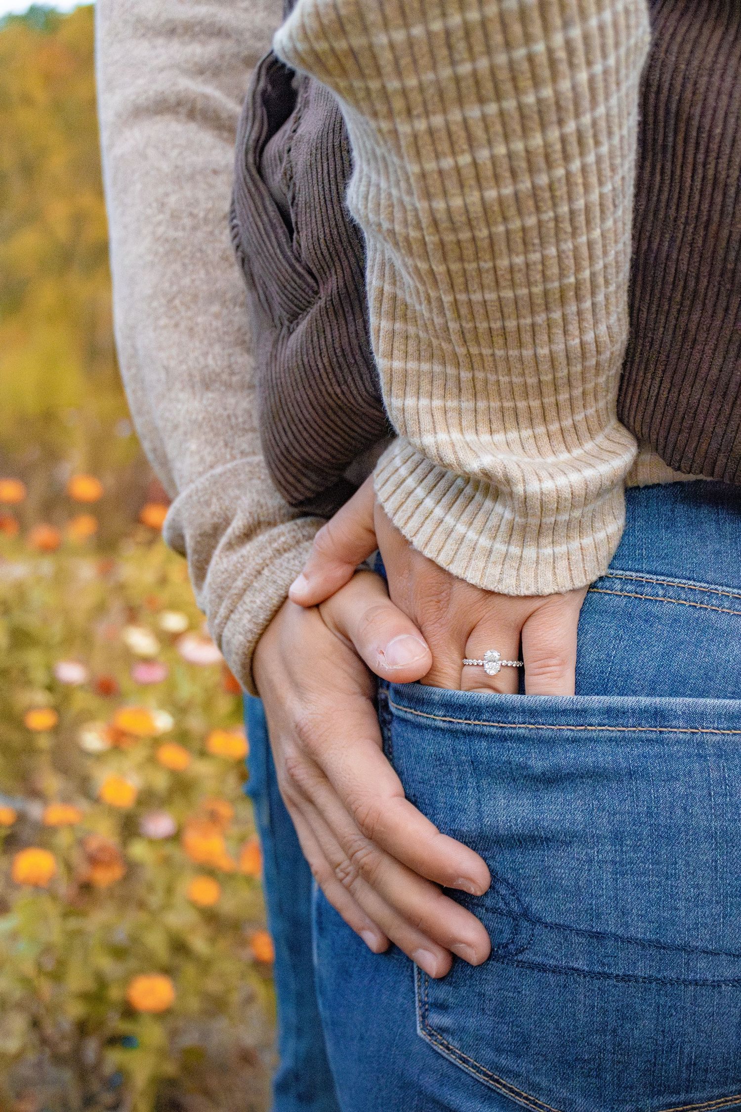Close-up of couple embracing showing engagement ring detail.