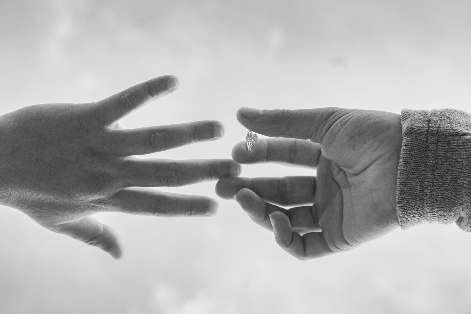 Black and white sequence showing hands reaching towards each other.