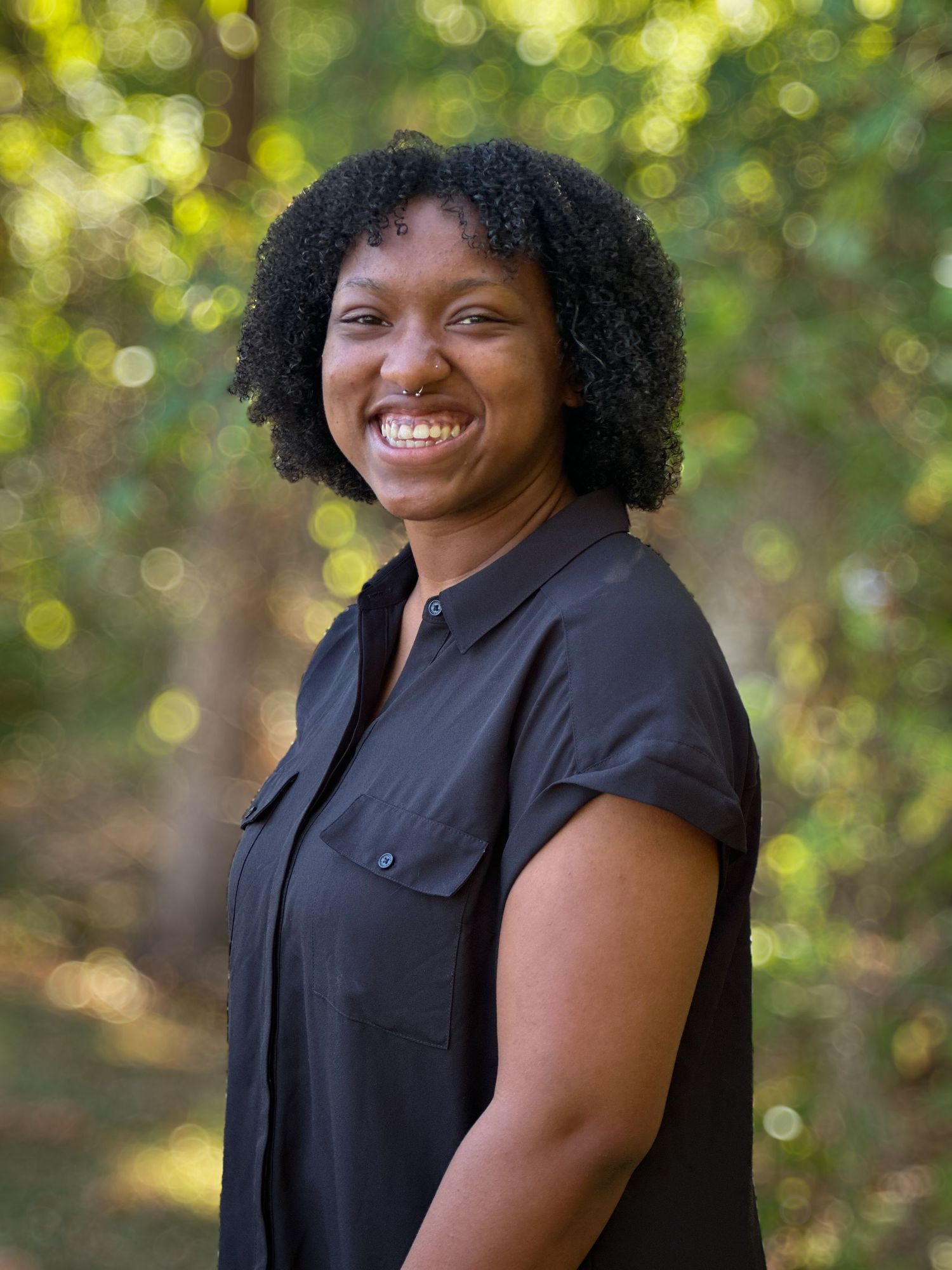 Outdoor portrait session showing joyful expressions against a sunlit natural backdrop.