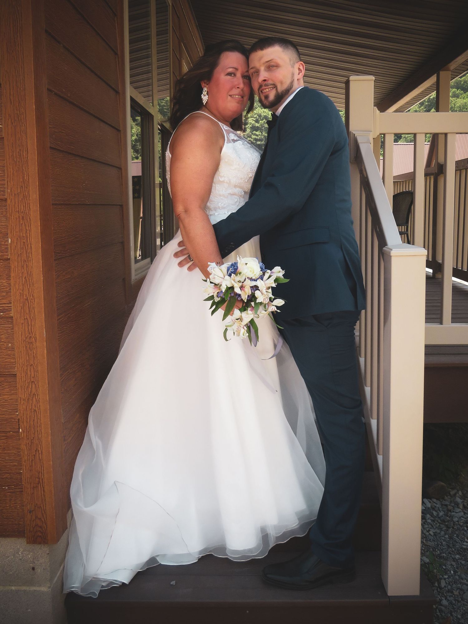 A romantic wedding photo series showing a couple embracing in a rustic wooden pavilion.