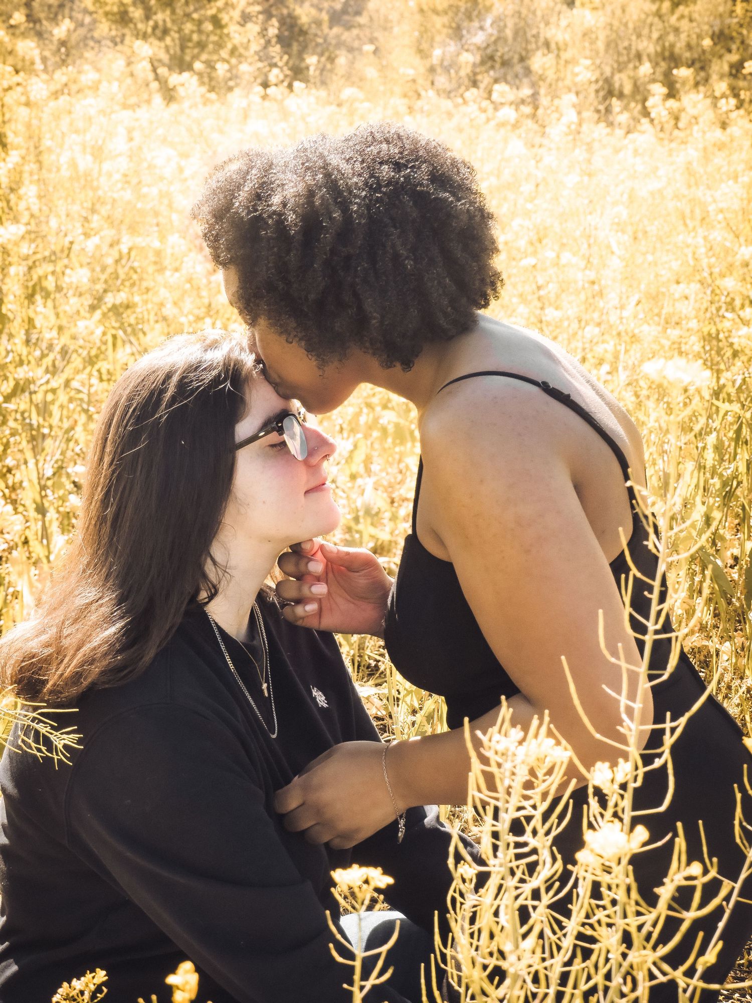 Romantic sunset photoshoot in a golden field with warm backlighting.