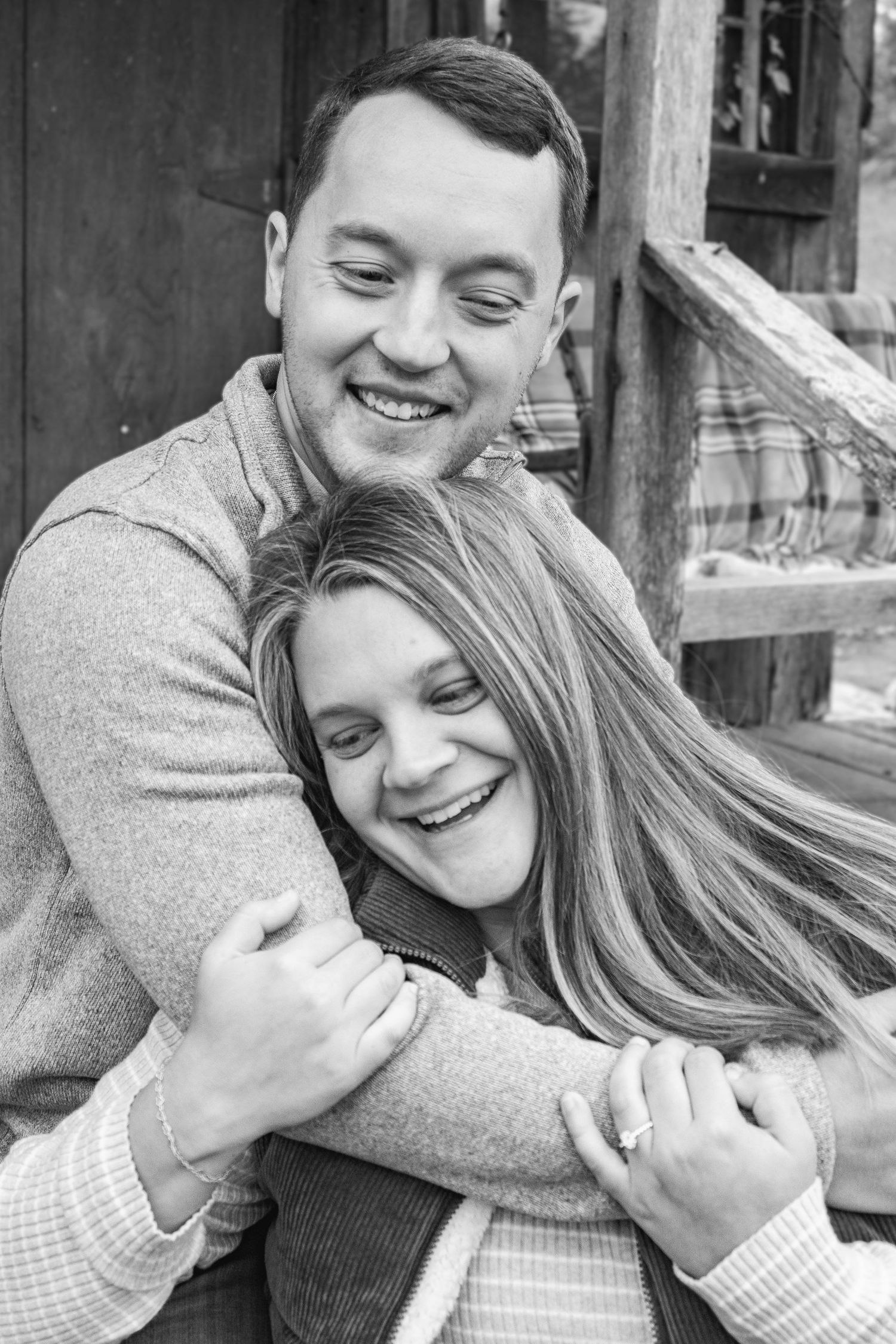 Black and white portrait of couple embracing and laughing together.