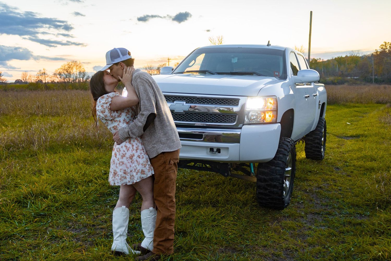 White pickup trucks parked in field during golden hour photoshoot.