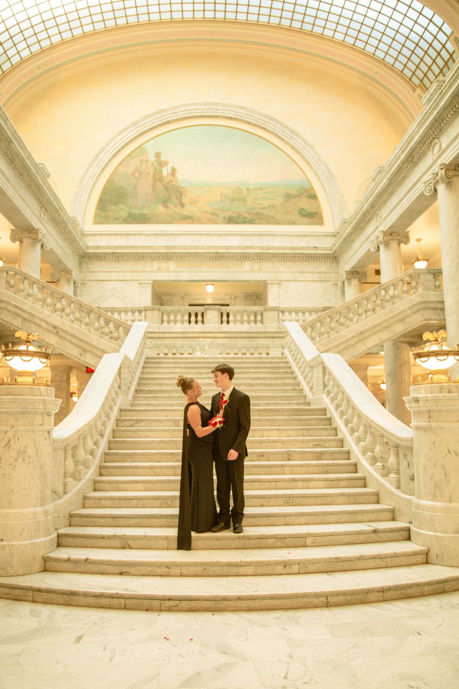 A panoramic view of an elegant marble staircase in a grand historic building with arched ceilings and ornate details.