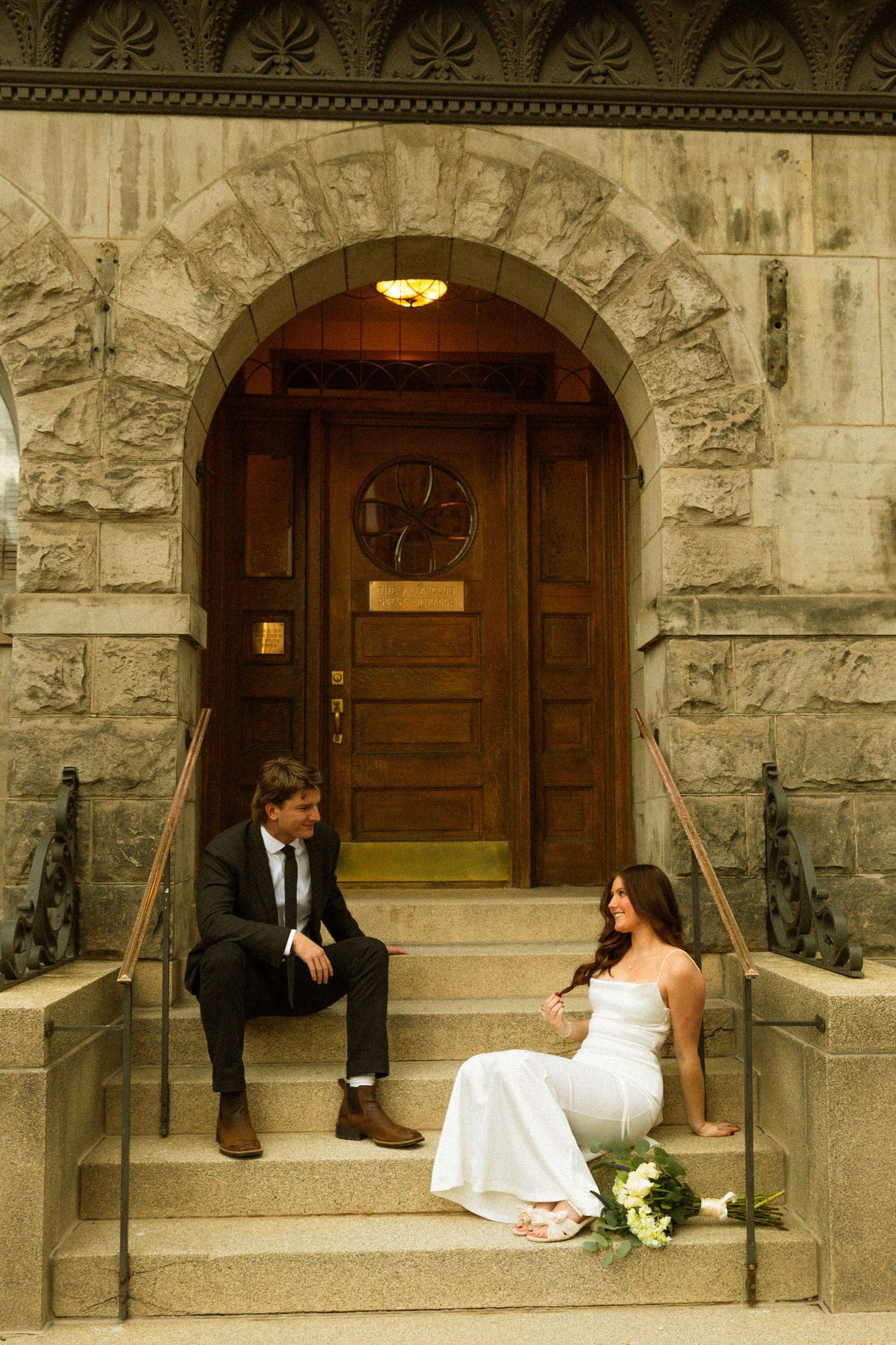A series of wedding photos showing a couple sitting on stone steps outside an elegant arched doorway entrance.