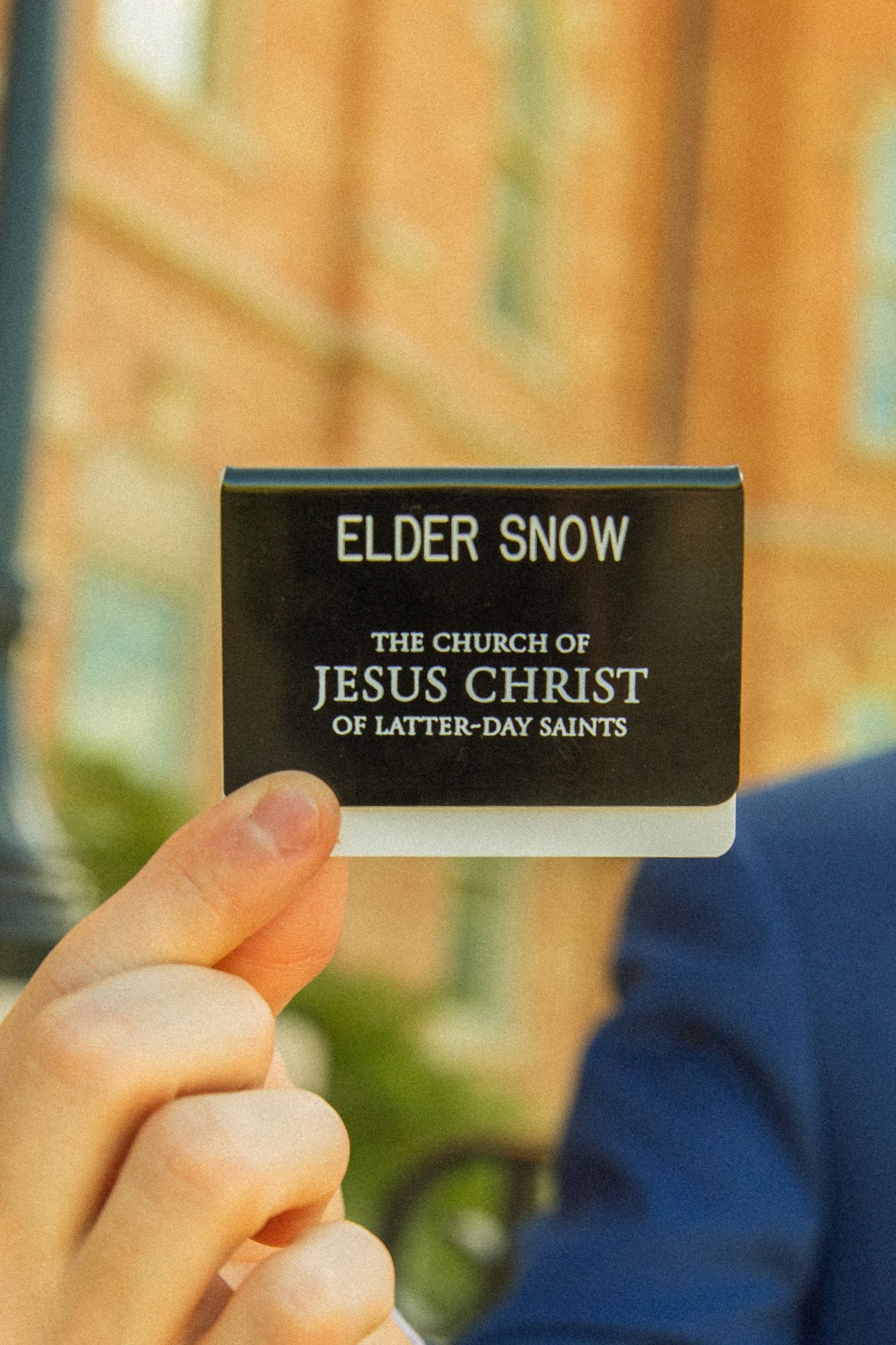 Three close-up photos showing a black name tag with 'Elder Snow' and 'The Church of Jesus Christ of Latter-day Saints' text.