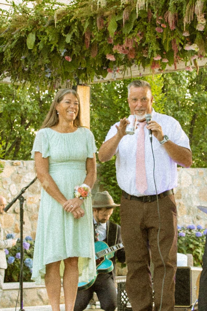 Performers in mint green and formal attire entertain guests under a vine-covered pergola.