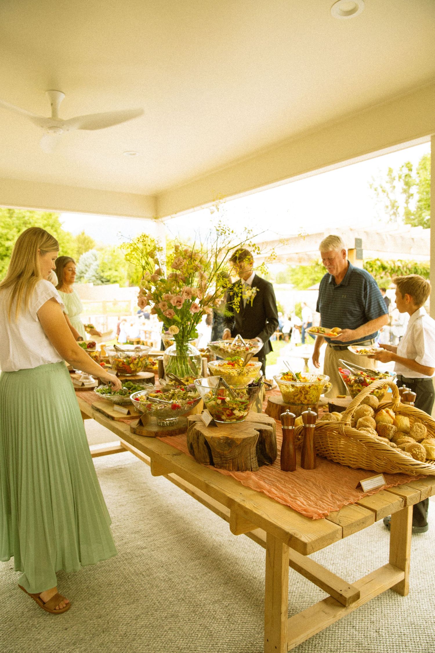 A buffet table filled with breads and food items at an outdoor reception venue.