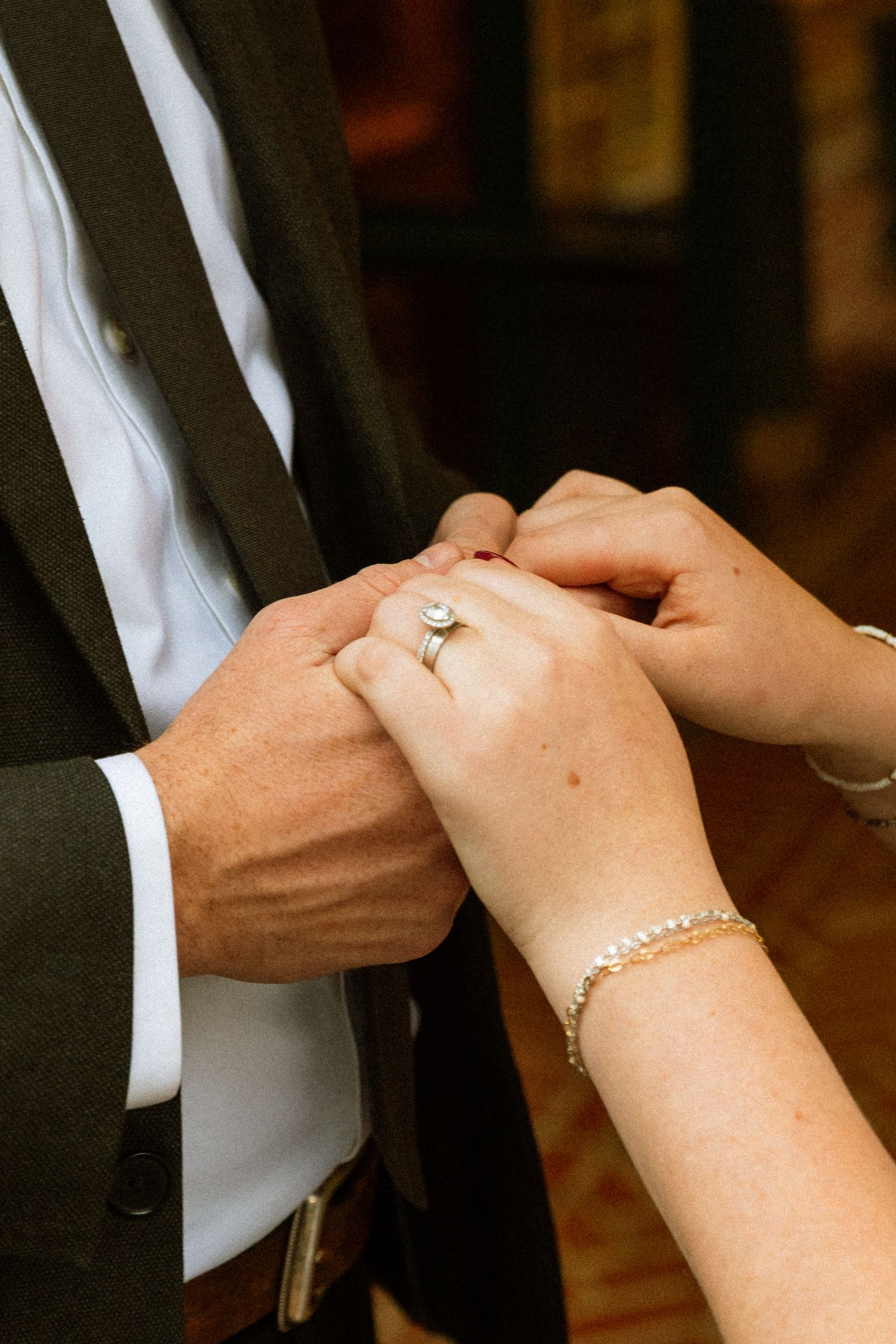 Close-up sequence showing hands exchanging wedding rings during a marriage ceremony.