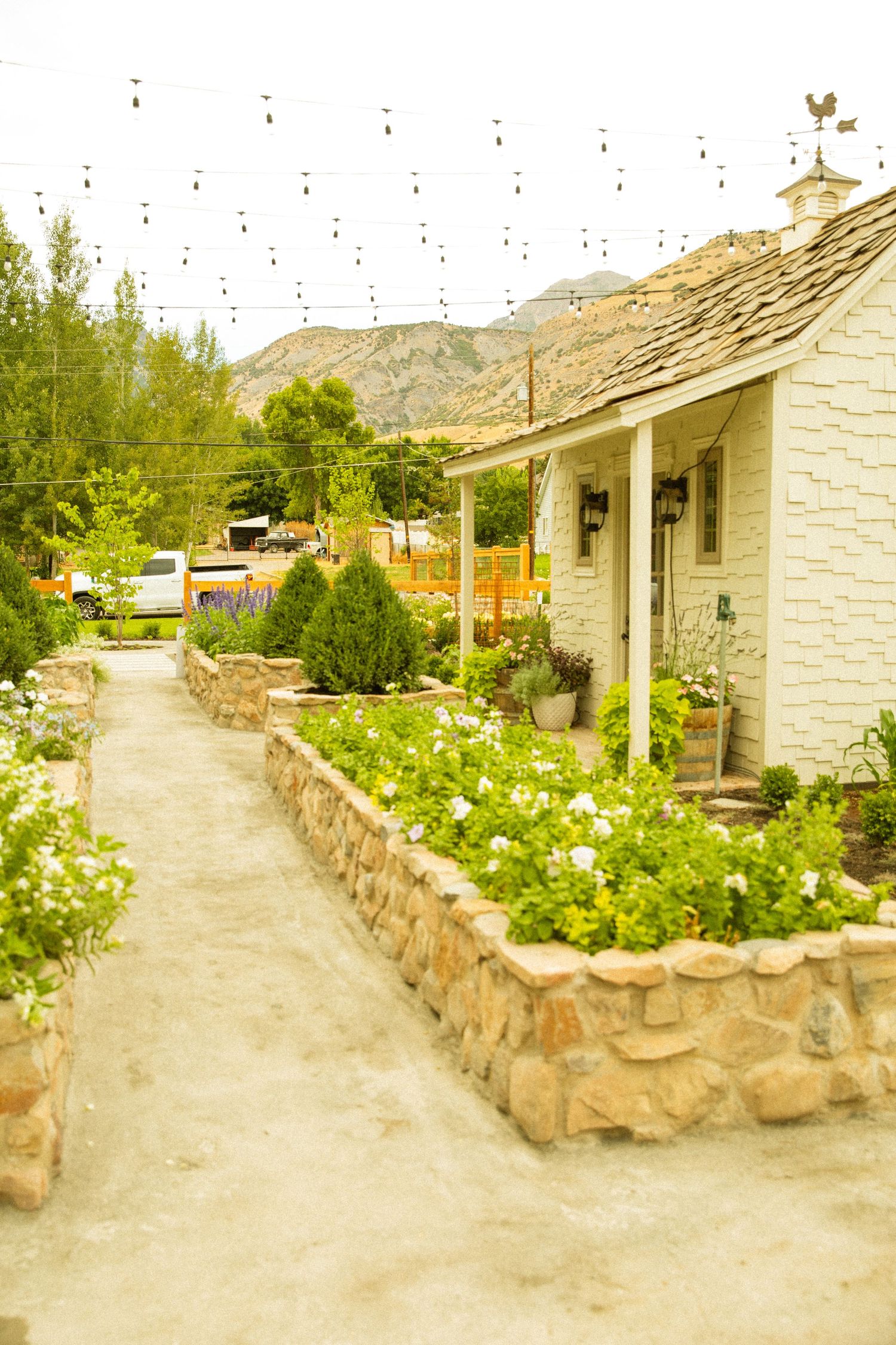 White stone cottages with flower gardens along a winding path.