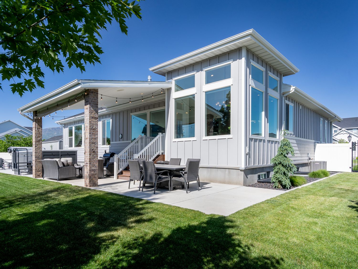 Contemporary home exterior with covered patio, large windows, and mountain views.