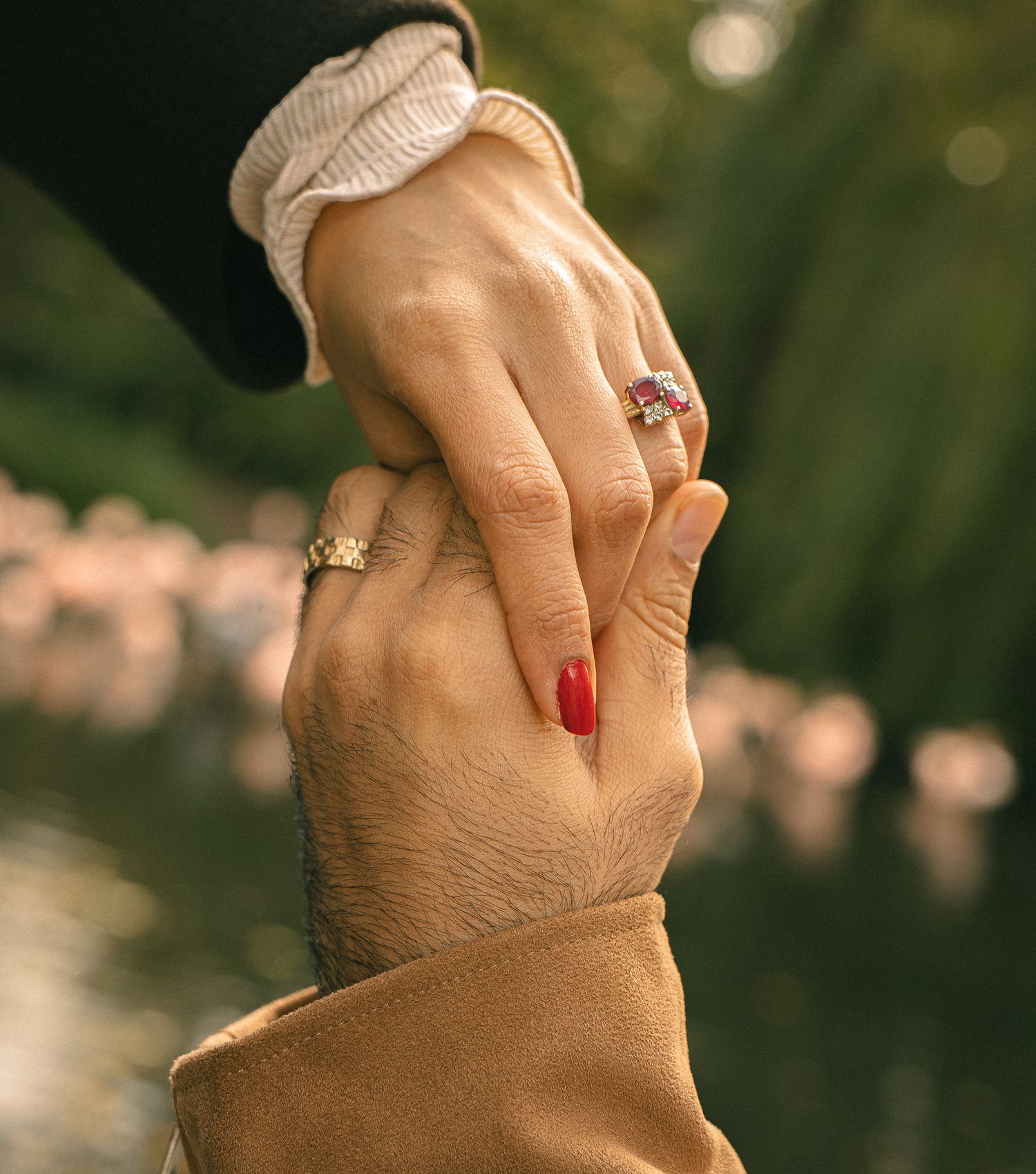 Romantic couple holding hands with their wedding bends showing.