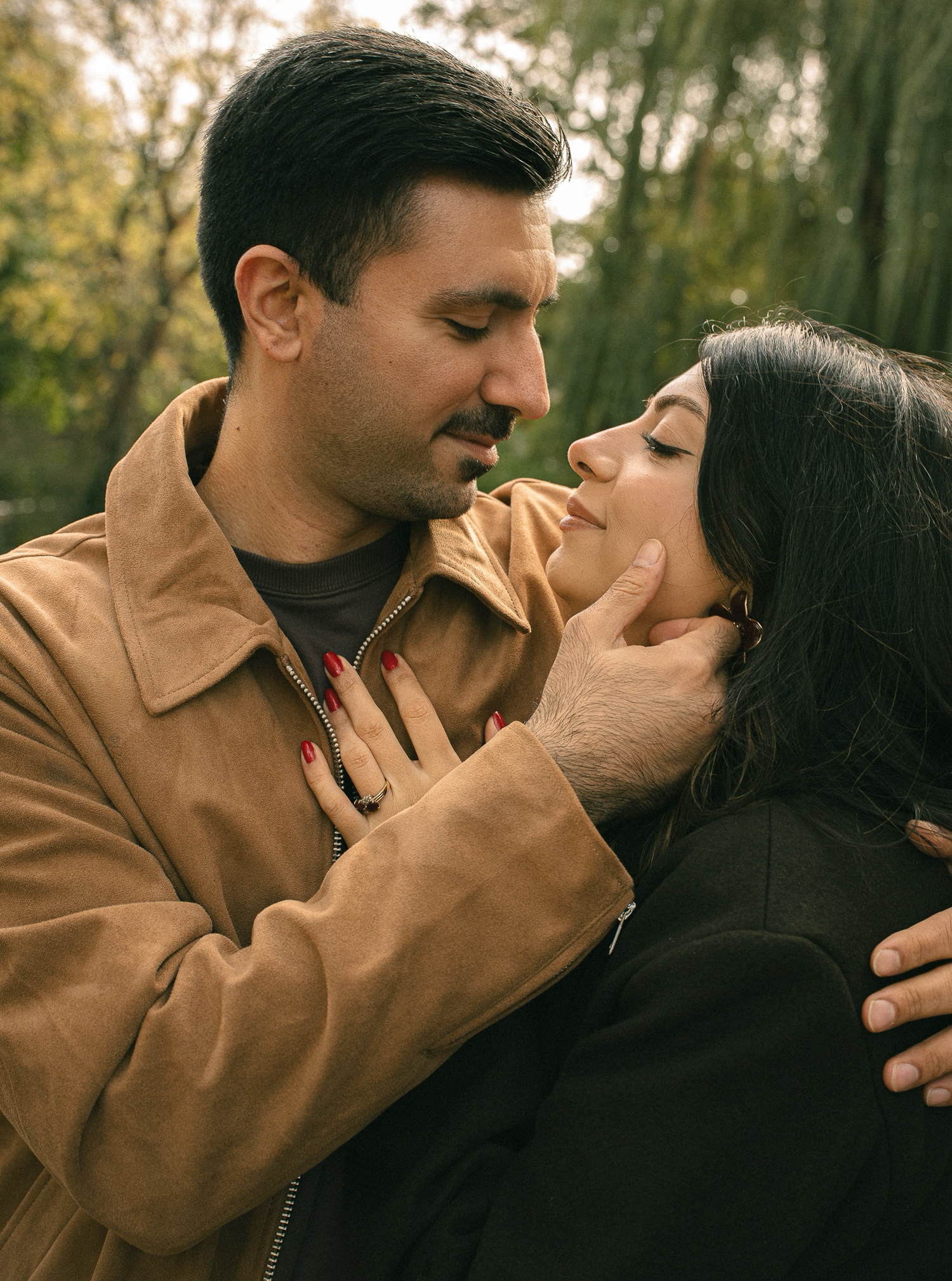 Romantic couple standing close together in soft warm light.