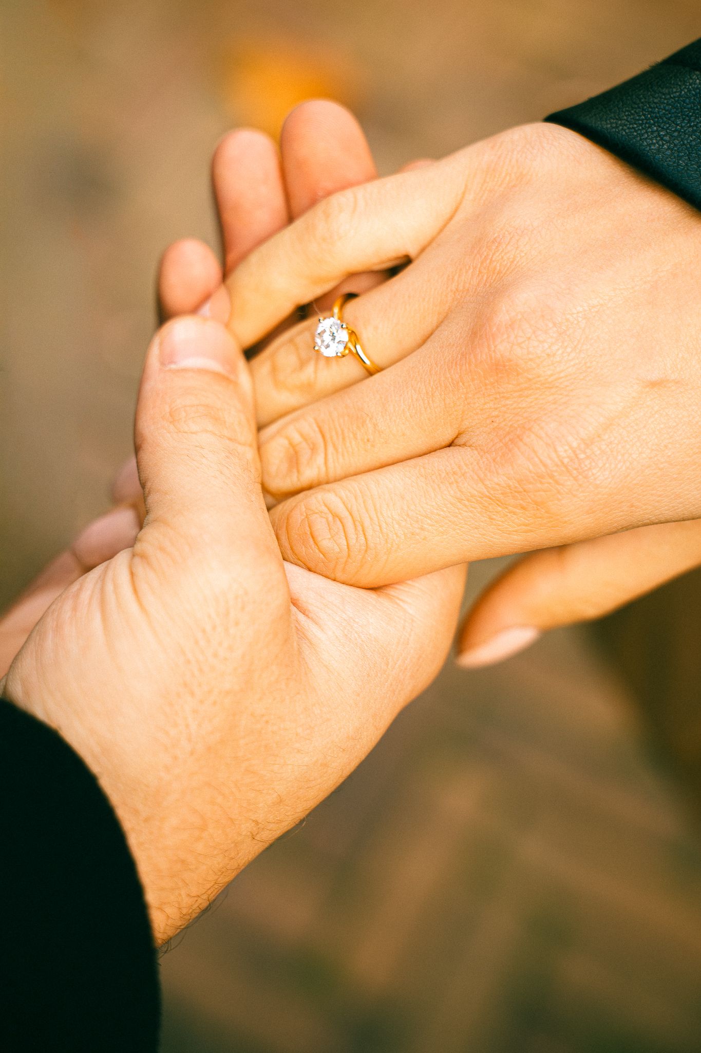 Romantic couple holding hands with their wedding bends showing.