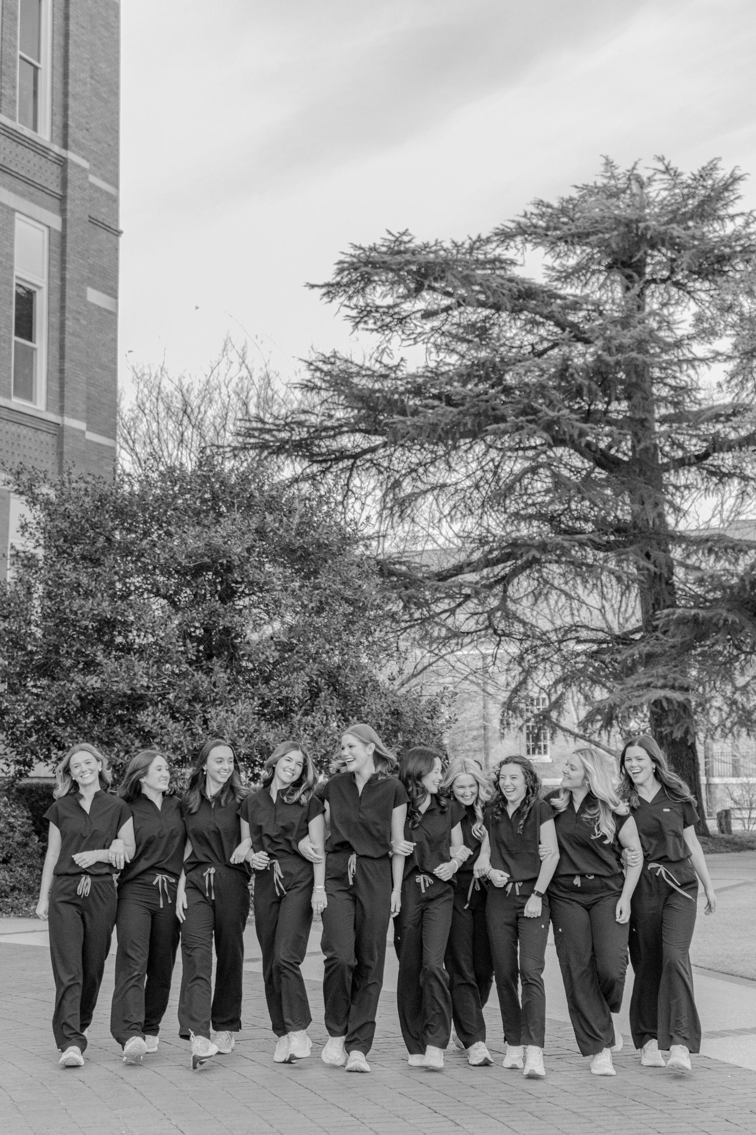Group photo of people in matching black outfits standing together outdoors.