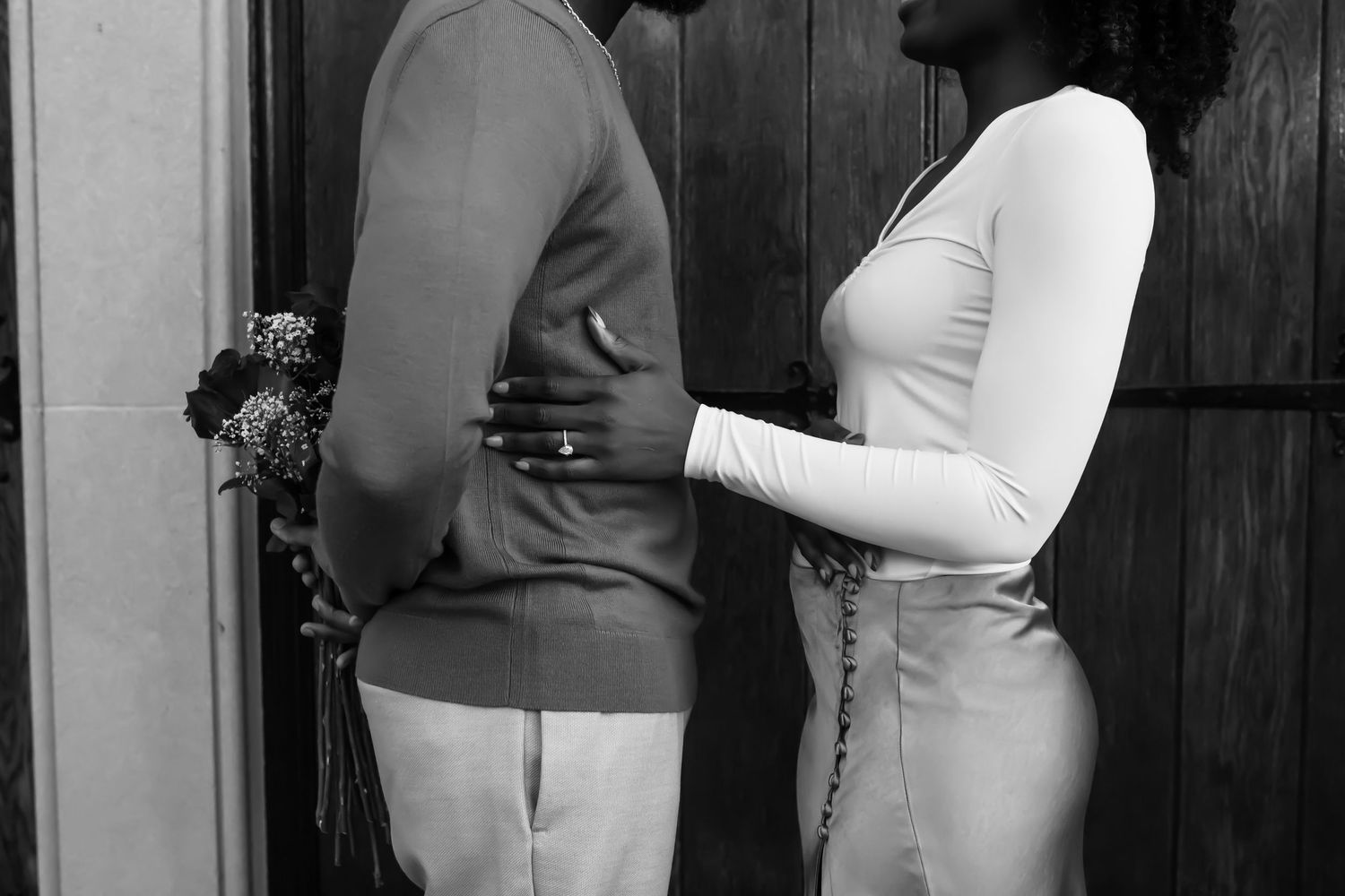 Black and white intimate portrait of a couple in formal attire.