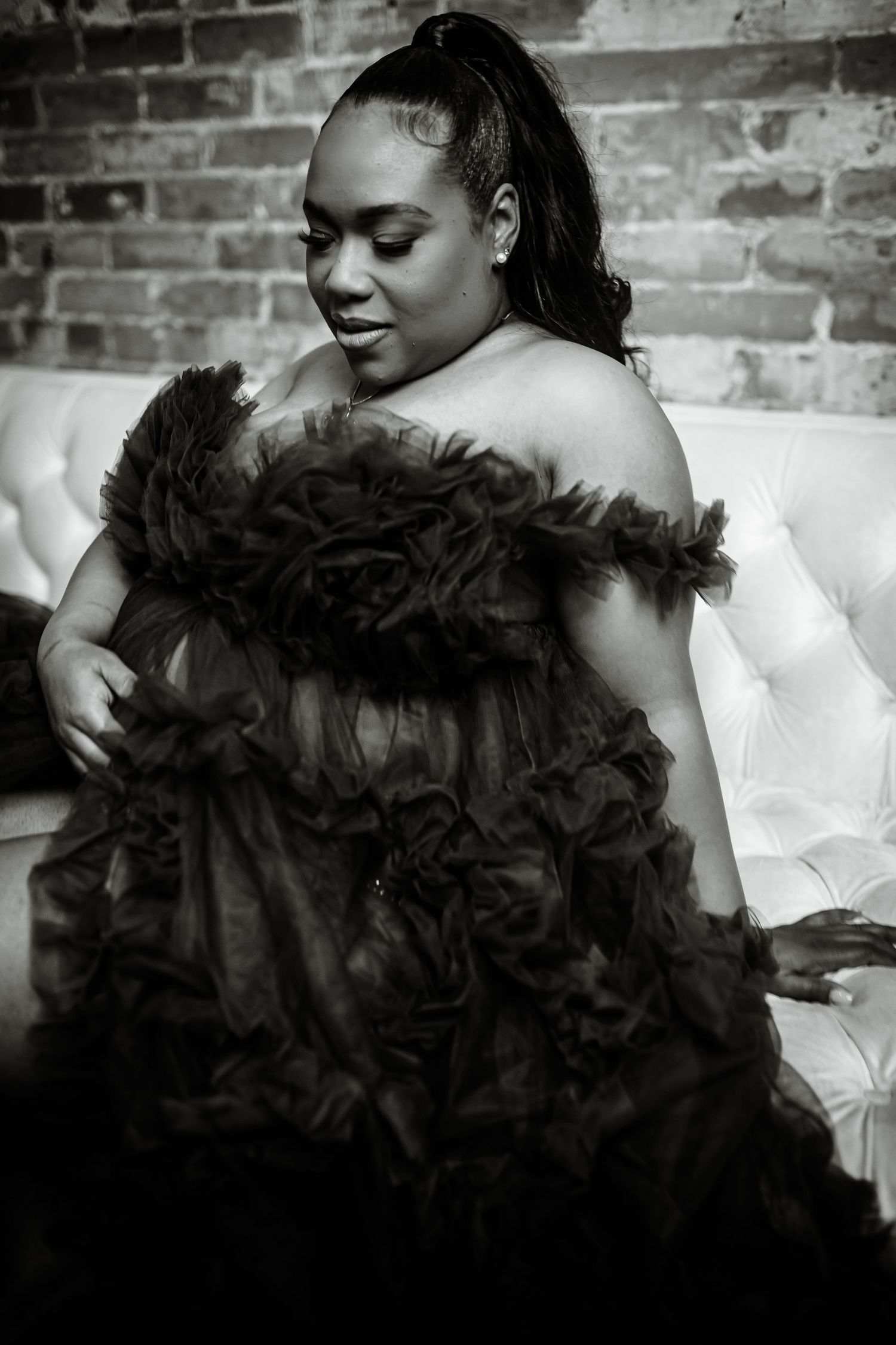 Black and white photo series showing someone in a white top posing with dramatic black feathered accessories.