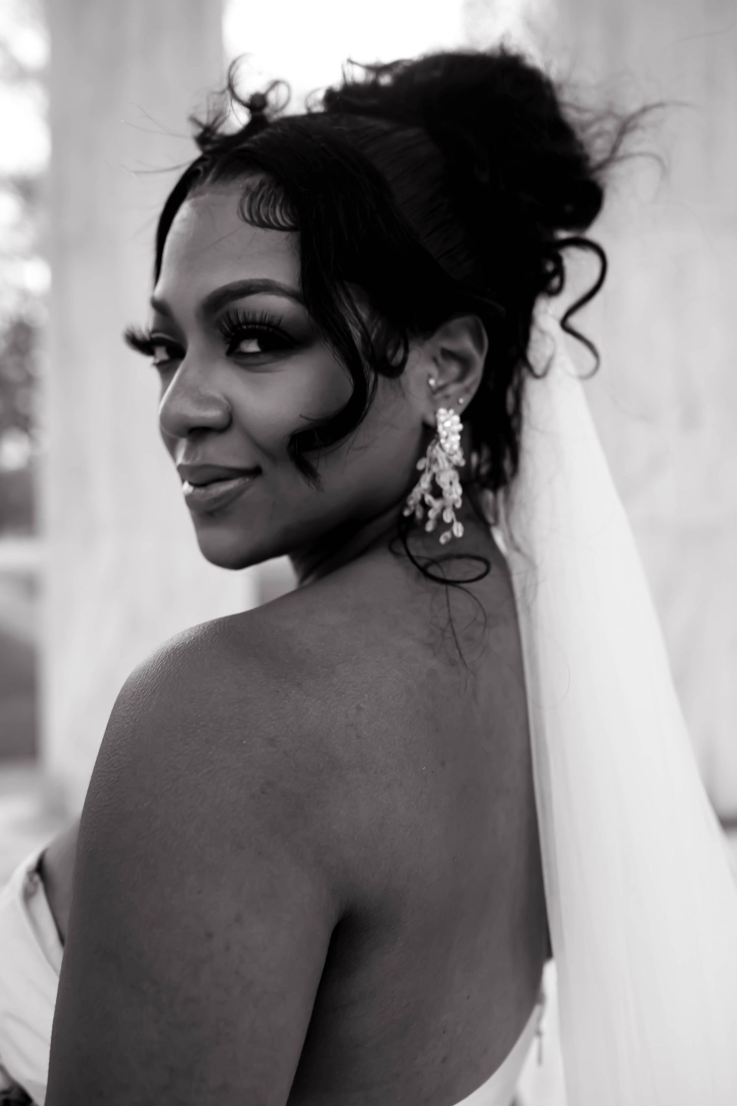 Black and white portrait showing elegant bridal details against white columns.