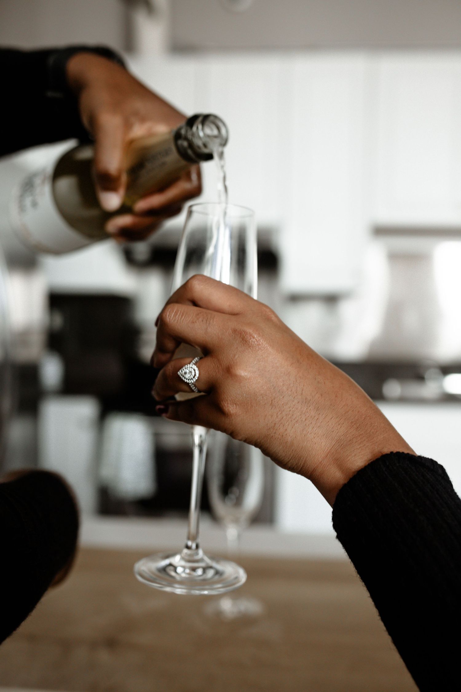 Close-up details of hands holding champagne glasses in a modern setting.
