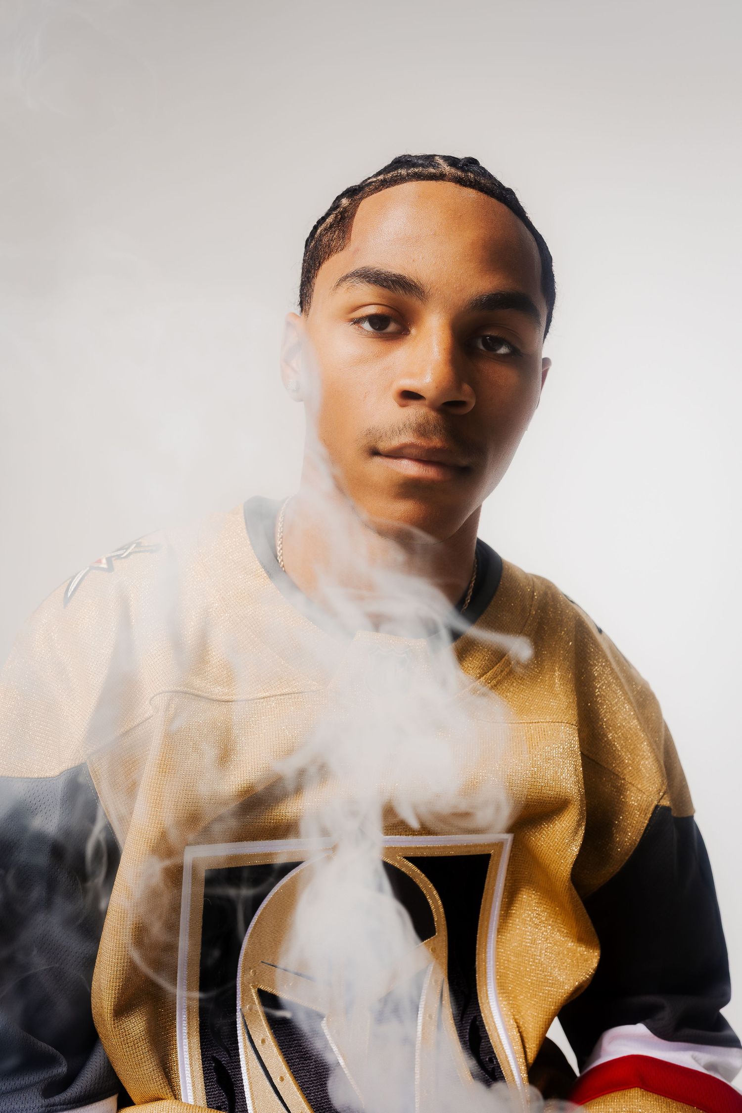 Artistic portrait with smoke effects against white background featuring yellow and black clothing.