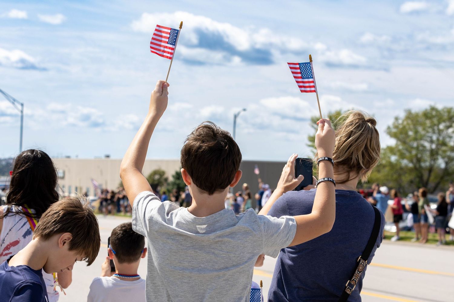 young child waving american flags as he cheers on the 50 mile march marchers