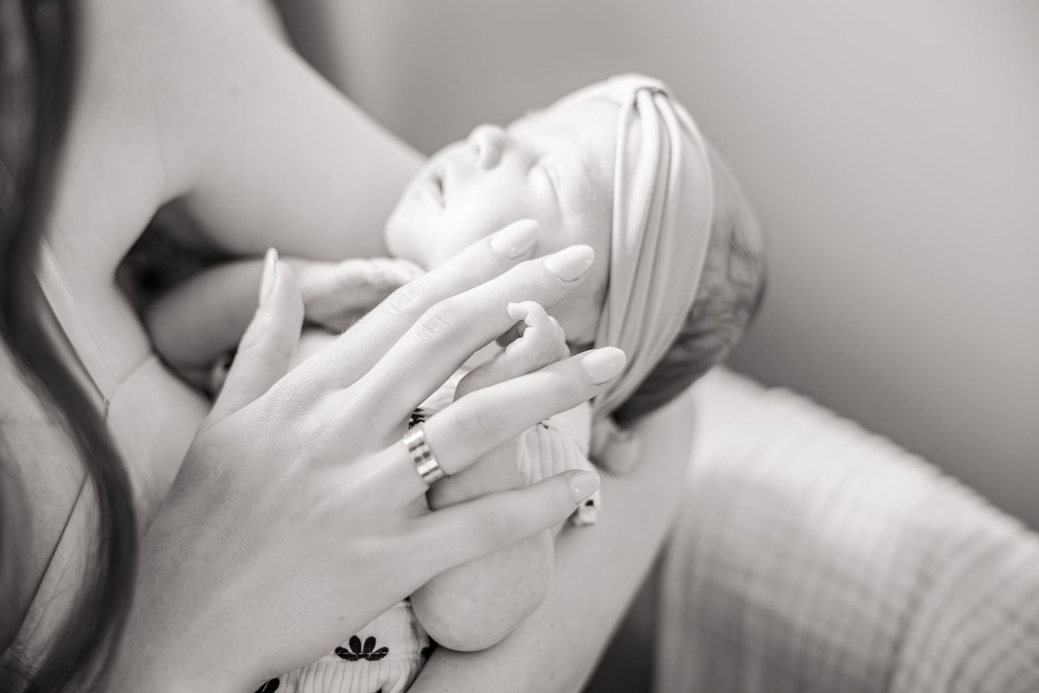 Close-up of hands tenderly touching in black and white.