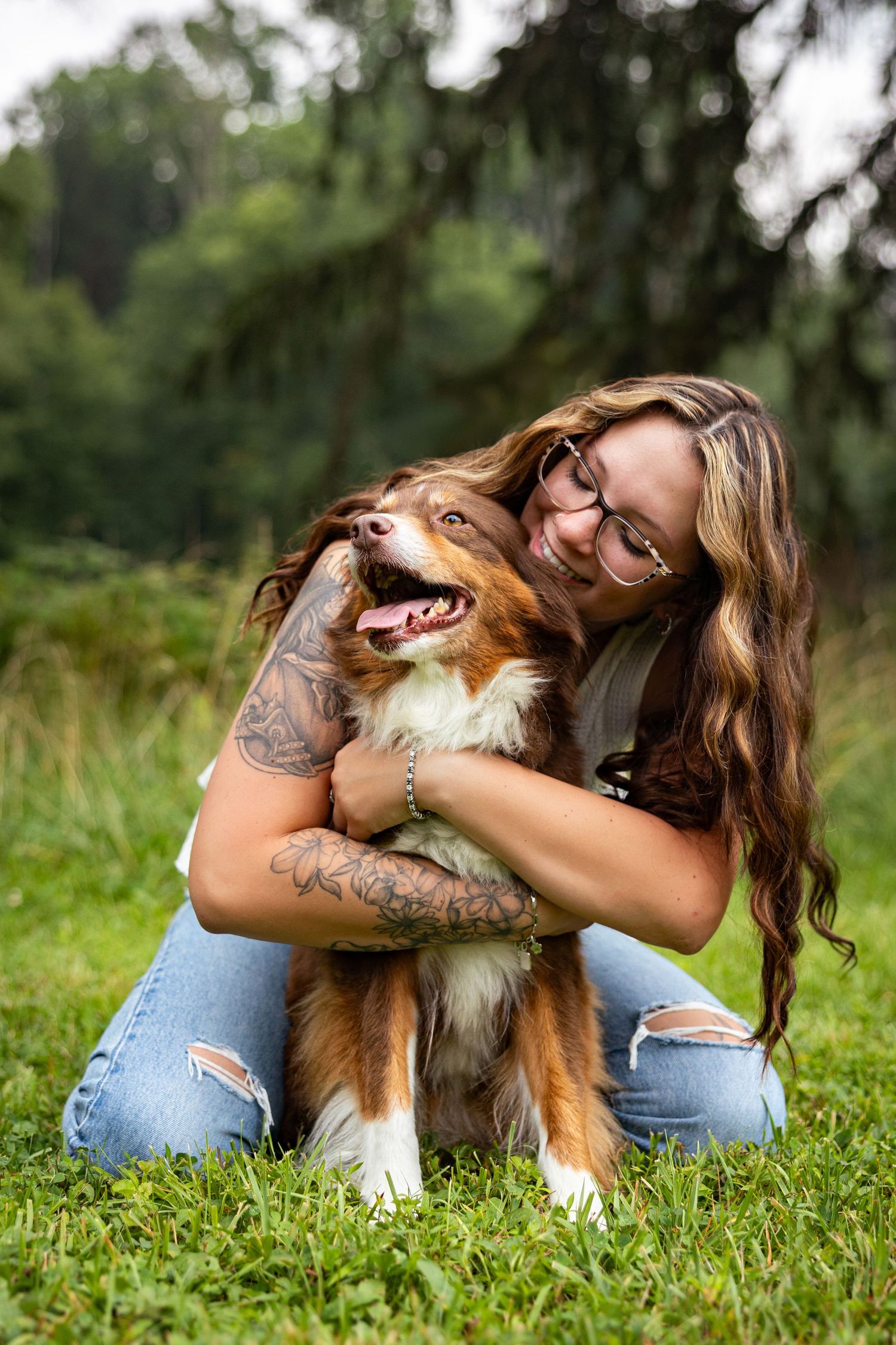 Playful Australian Shepherd dog and owner bonding in a grassy field.