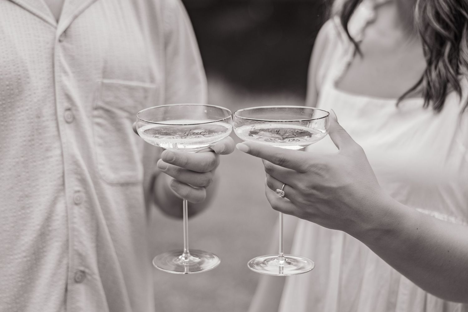 Elegant white dessert plates and glasses arranged on a white tablecloth.