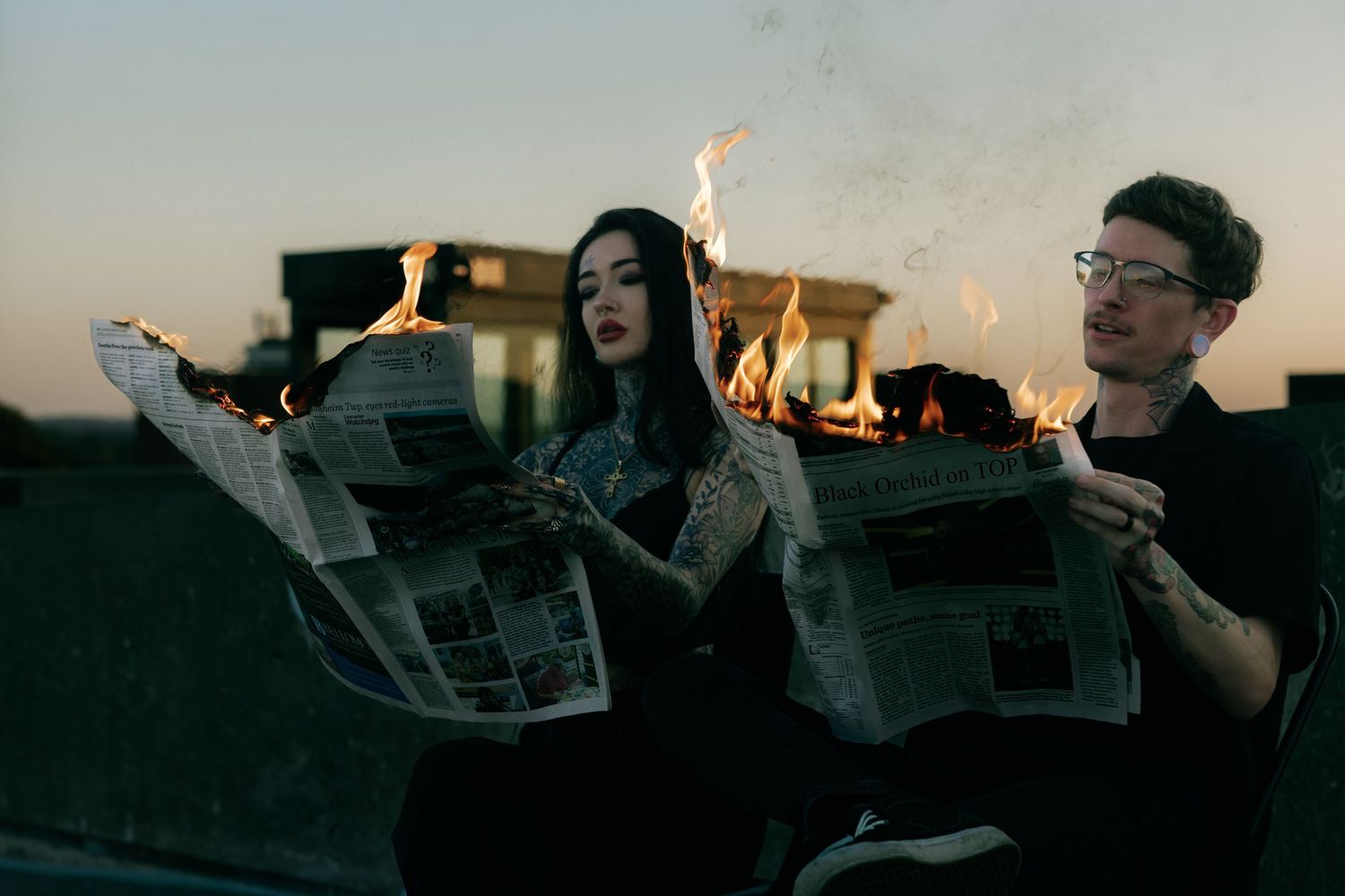 Friends reading newspapers together at sunset creating silhouettes.
