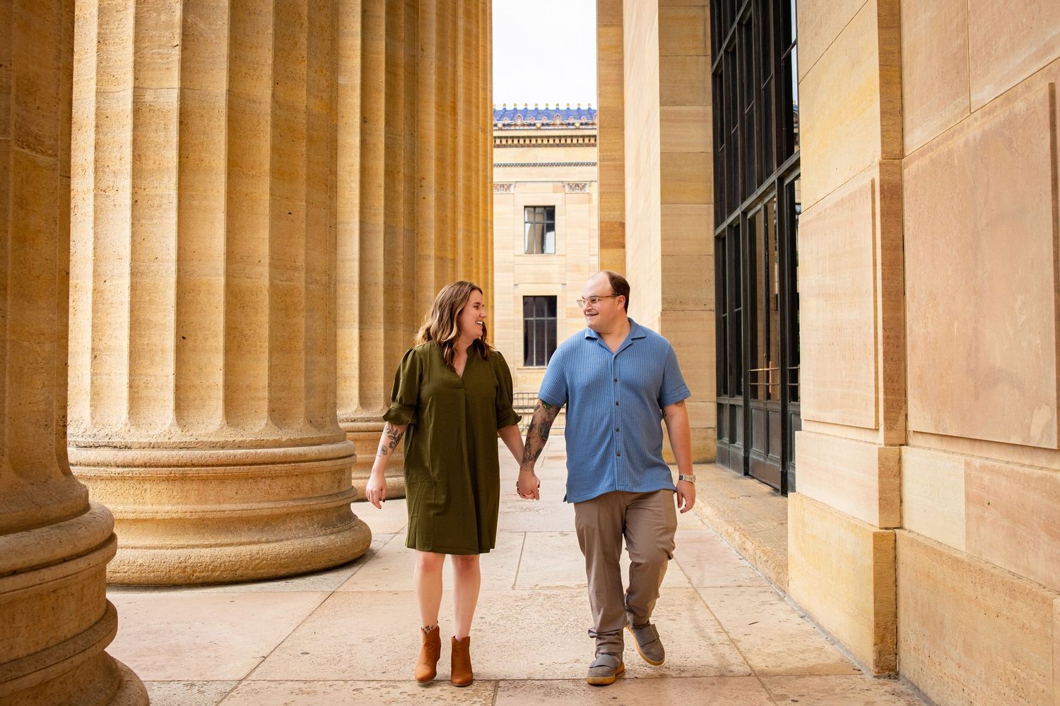 Classical architecture with stone columns creating dramatic shadows in warm sunlight.