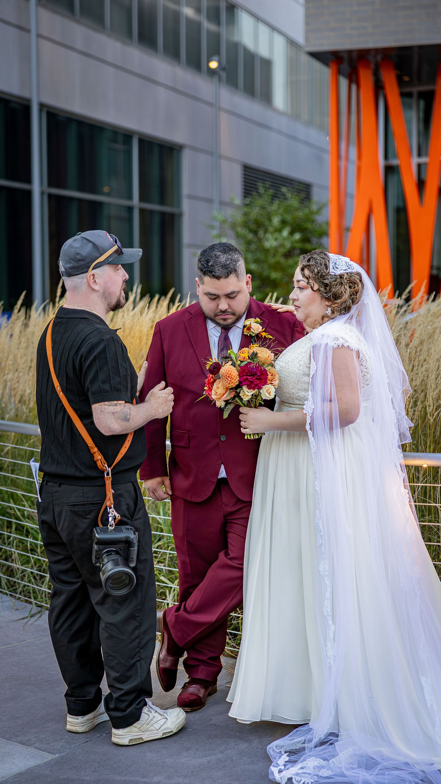 A sequence of wedding photos showing a couple in burgundy and white sharing intimate moments near a modern building.