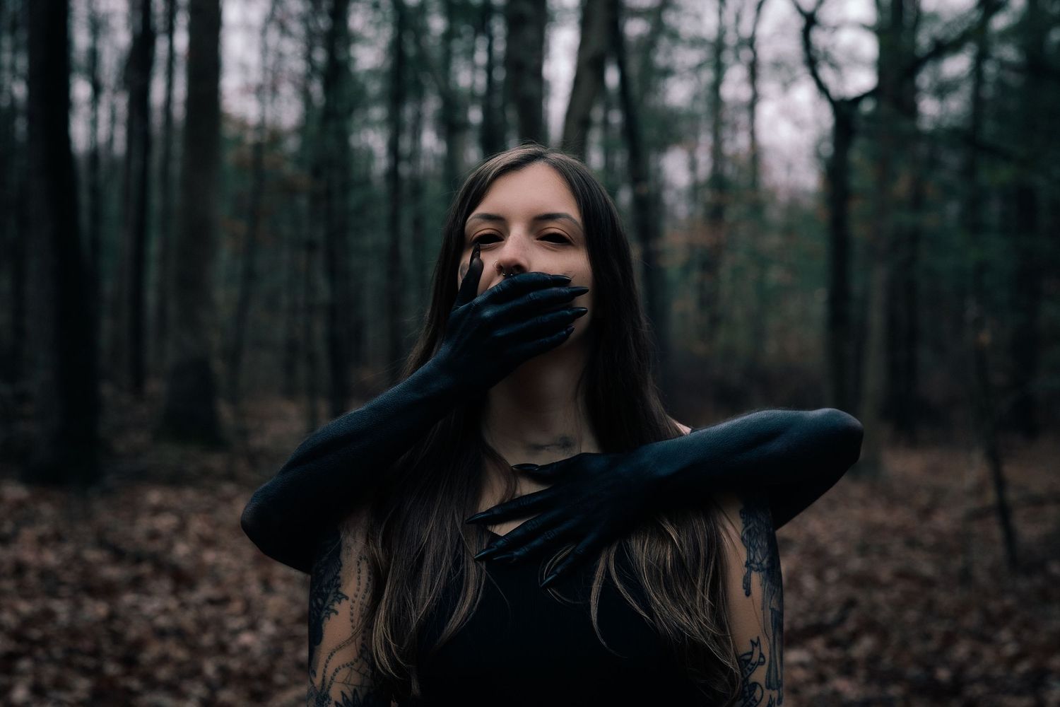 Moody forest portraits showing dramatic poses in a dark wooded setting.