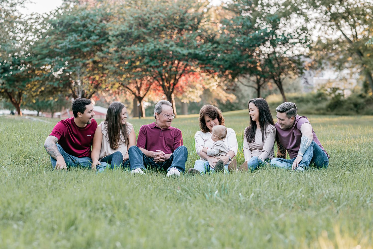 Group of friends relaxing together on grass in a park setting.