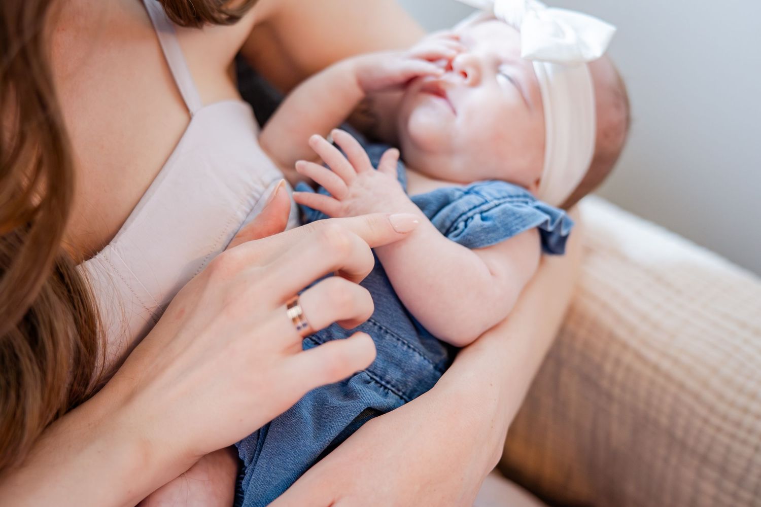 Mother gently holding and bonding with newborn baby in soft natural light.