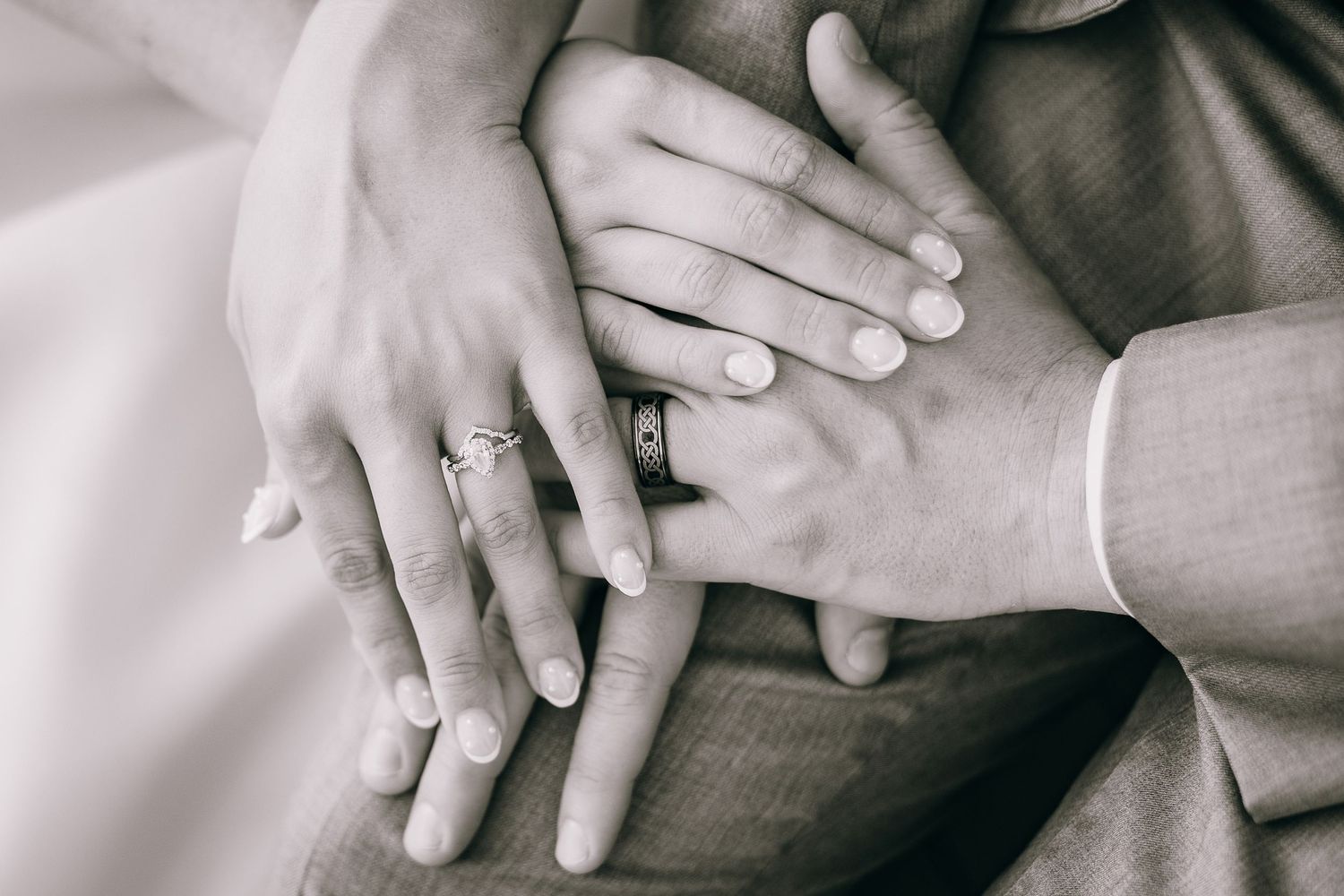 Close-up series of hands with engagement ring in black and white.