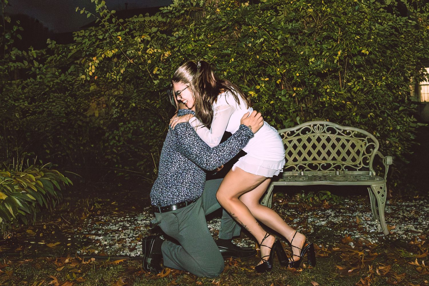 Romantic garden photoshoot with vintage furniture and lush greenery creating an intimate atmosphere.