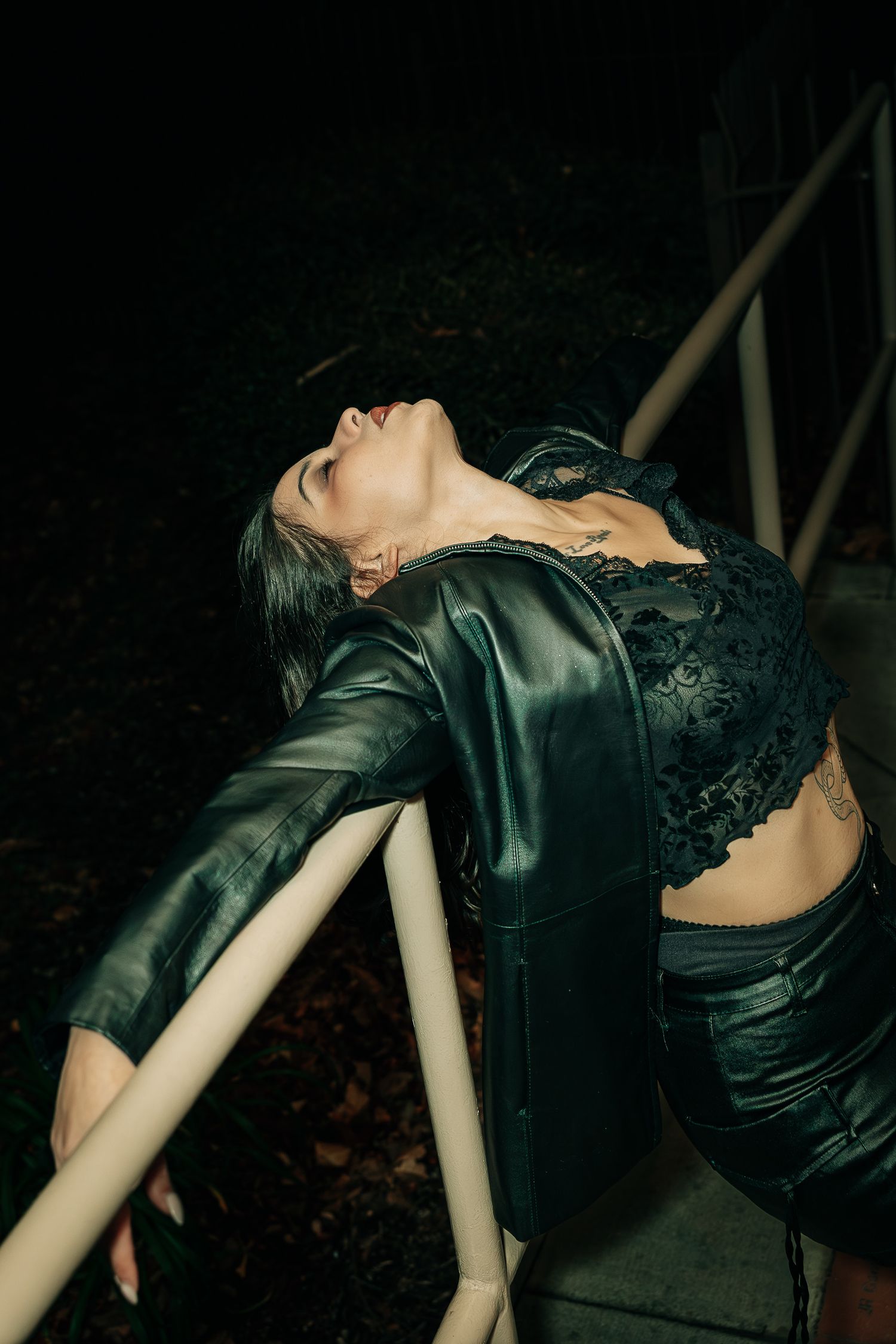 Artistic fashion photos showing a model in black leather and lace against a dark background.