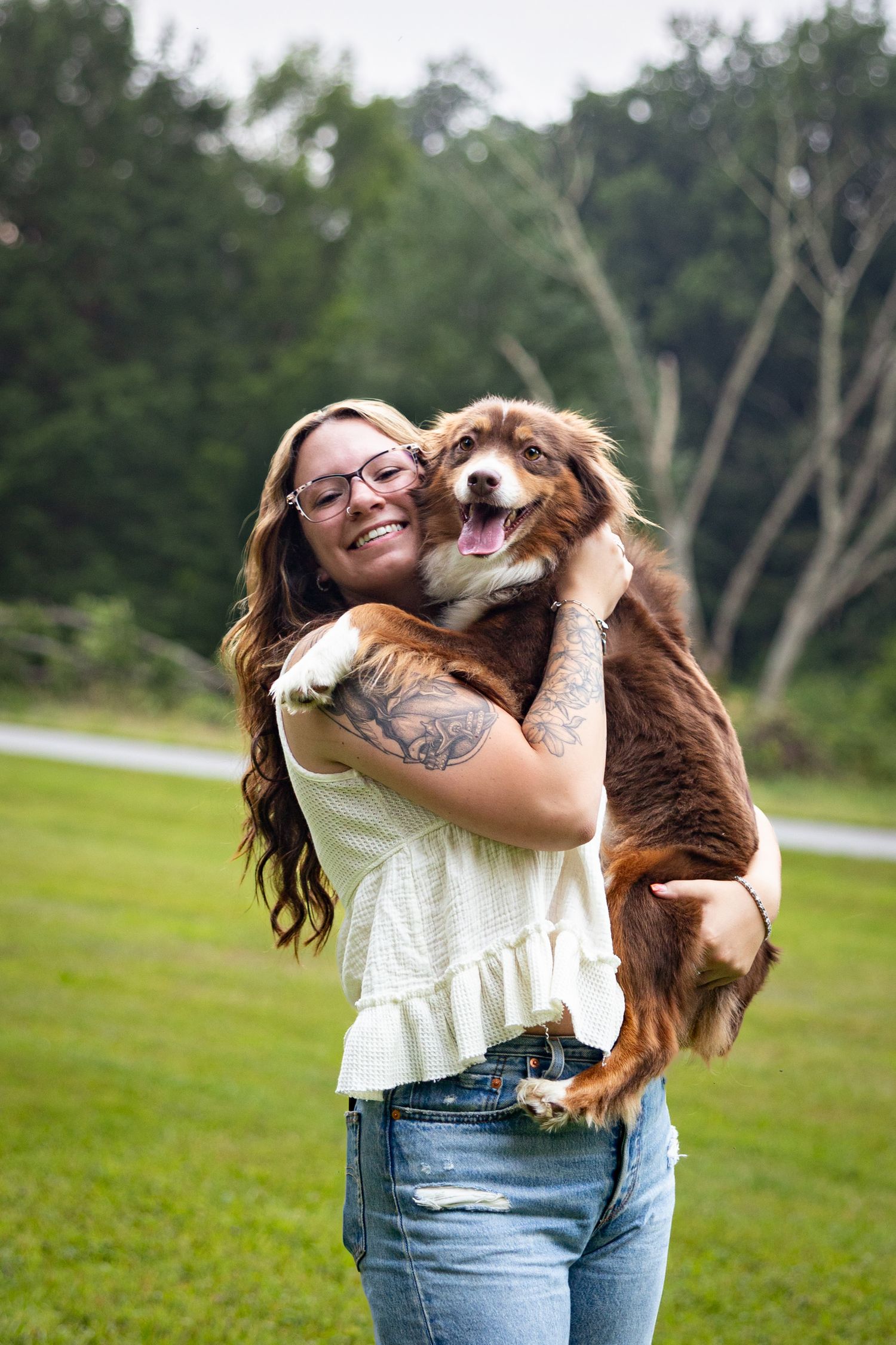Happy dog and owner playing together on a grassy field on a sunny day.