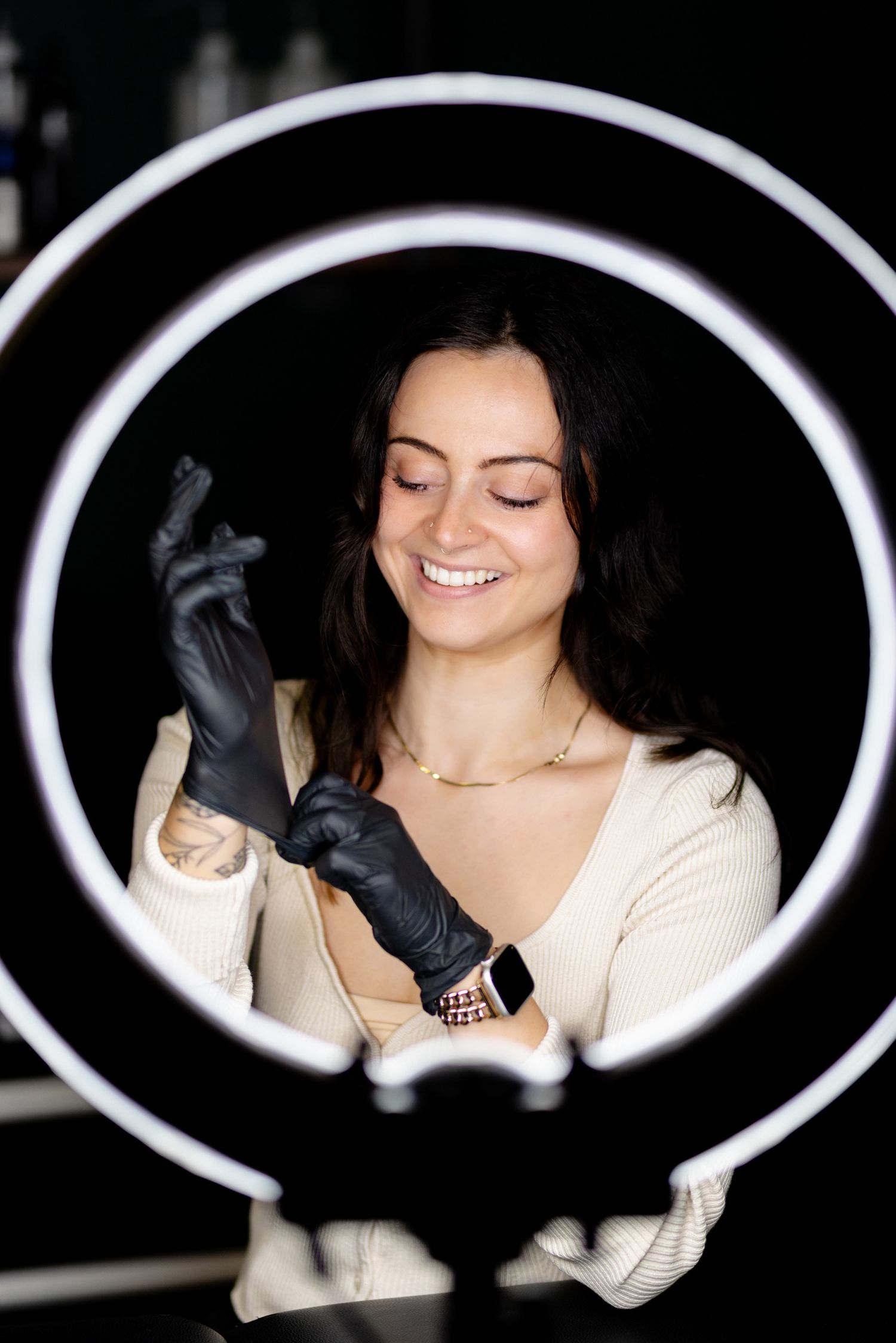 A sequence of five photos shows a person in a cream sweater wearing black gloves against a dark background with white oval frames.