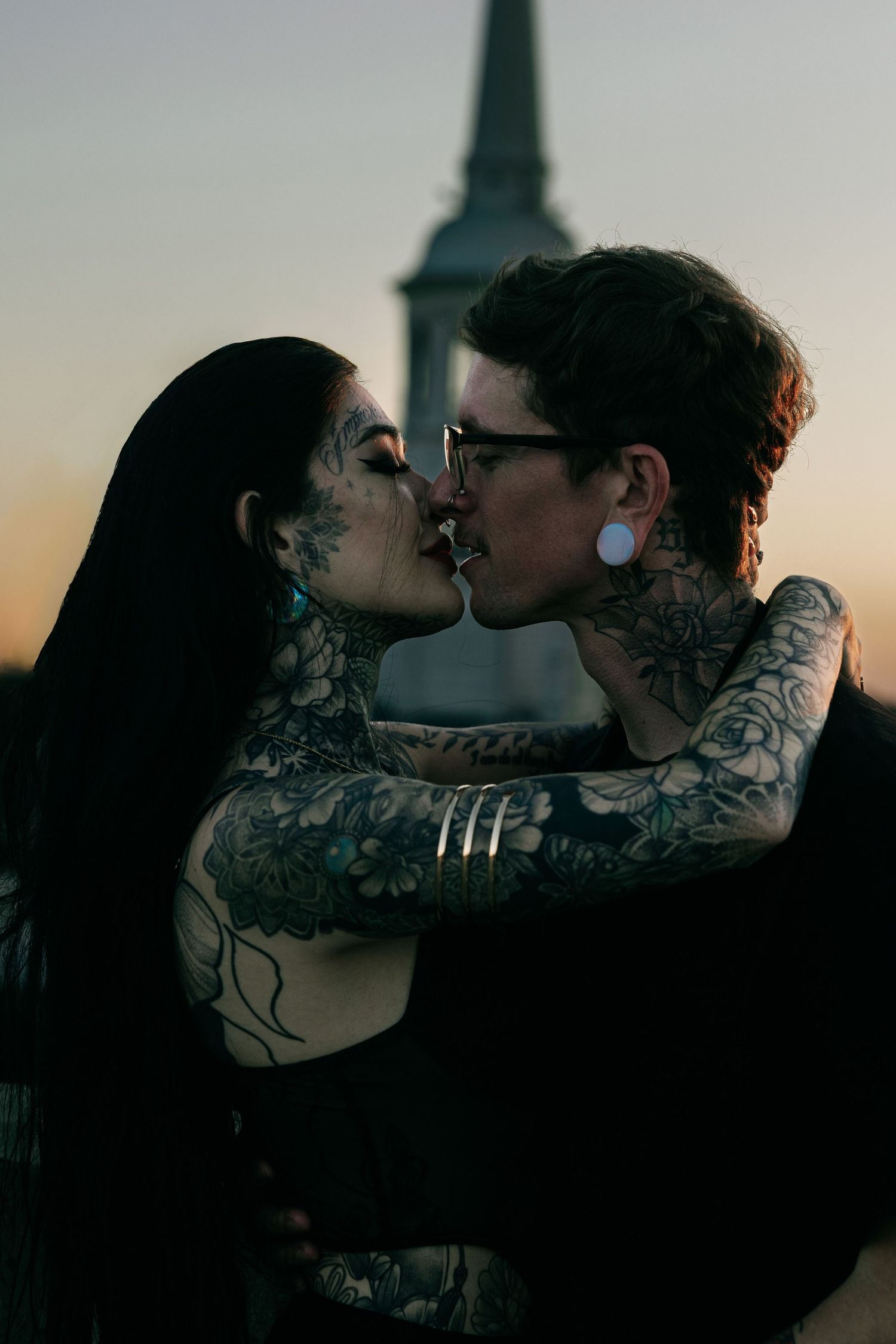 A romantic silhouette of a couple sharing a kiss against a sunset backdrop.