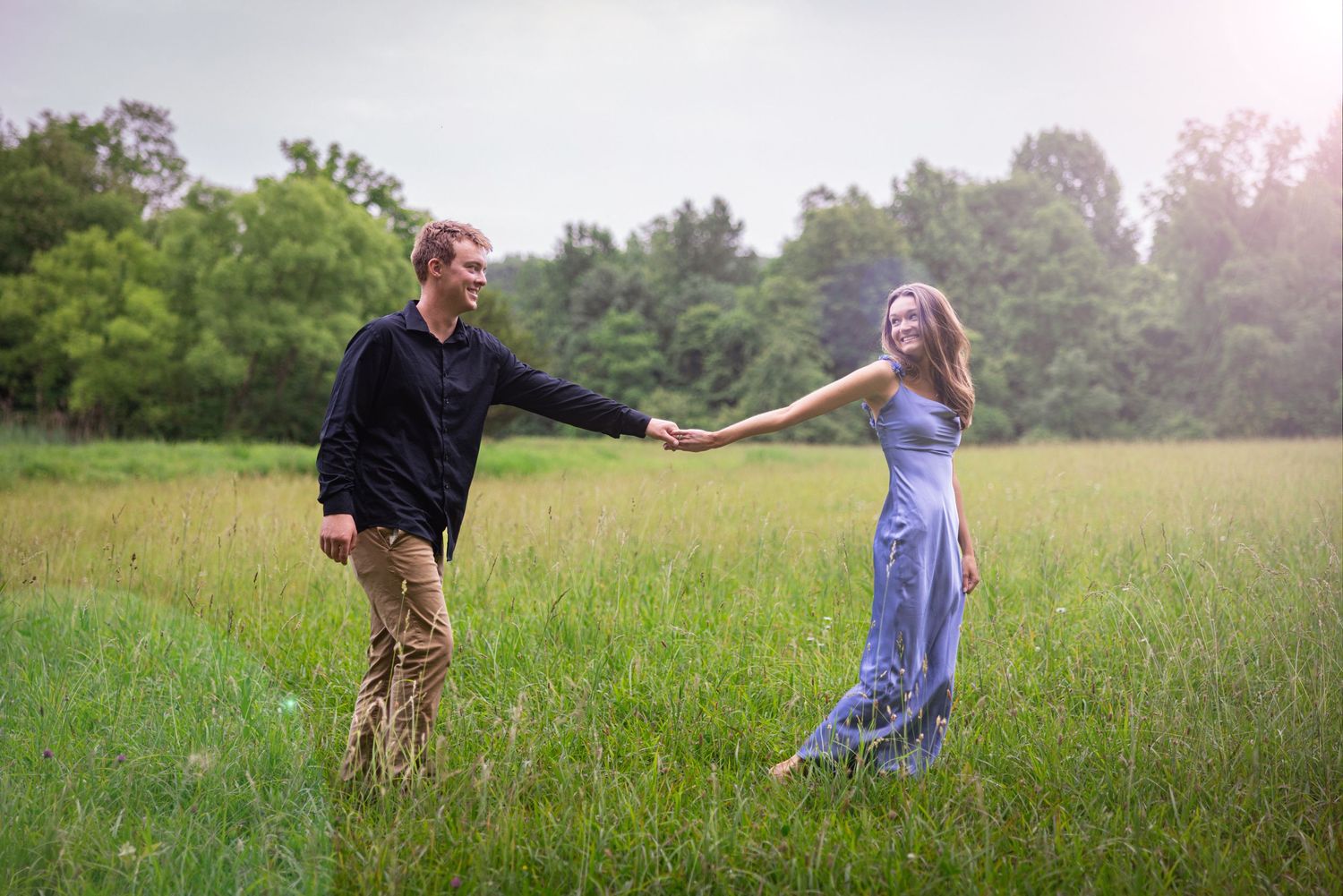 Couple walking and playing together in a sunlit meadow.